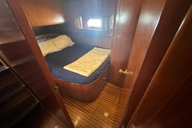 Cozy cabin interior of 2001 Horizon 56 yacht with wooden finish and bed.