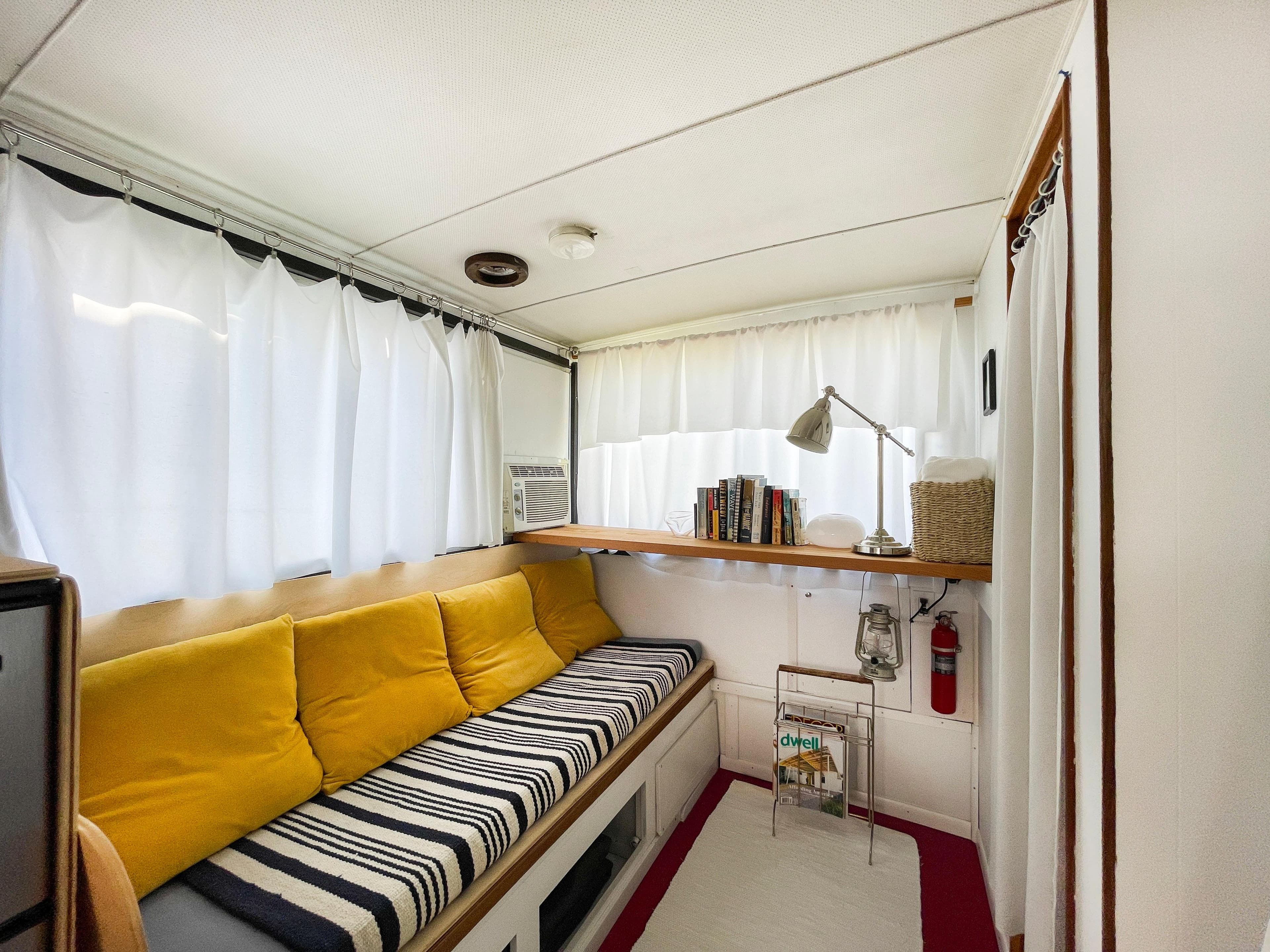 Cozy interior of 1970 Tollycraft Tollyhome 36 with yellow cushions and striped bench.