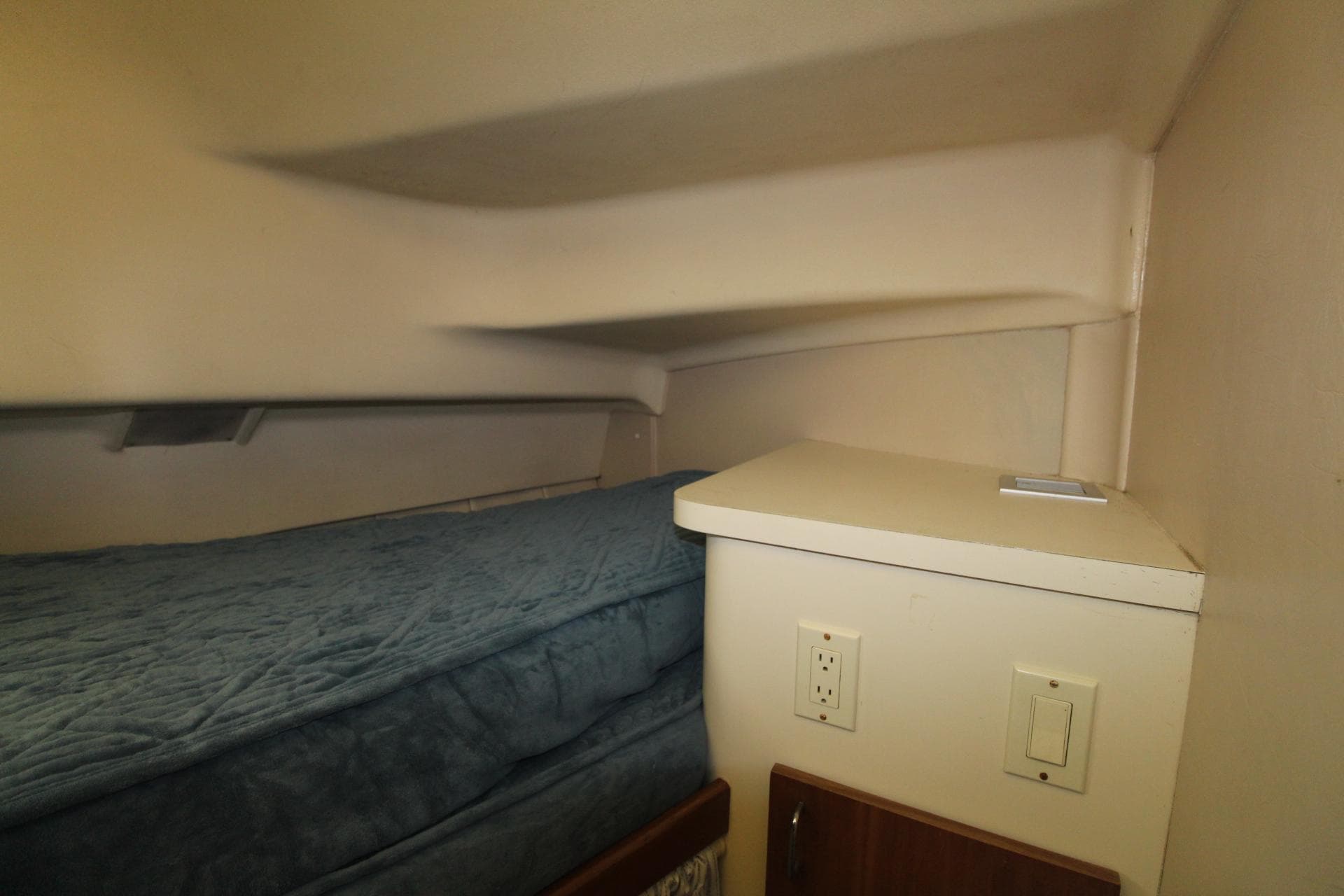 1999 Mainship 31 Sedan Bridge cabin interior with bed and electrical outlets.