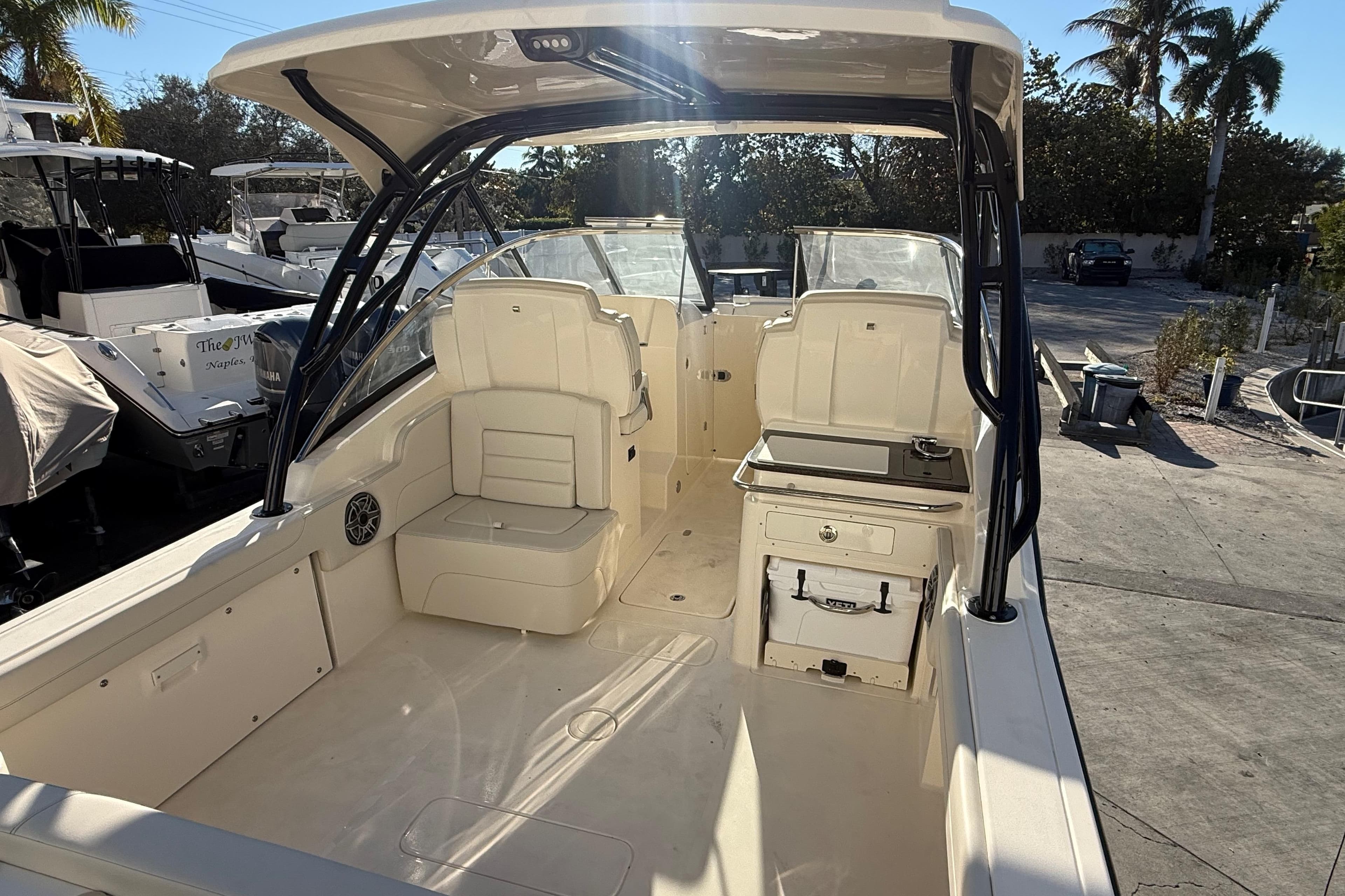 2026 Scout 255 Dorado boat interior with seating and storage, docked under sunny skies.