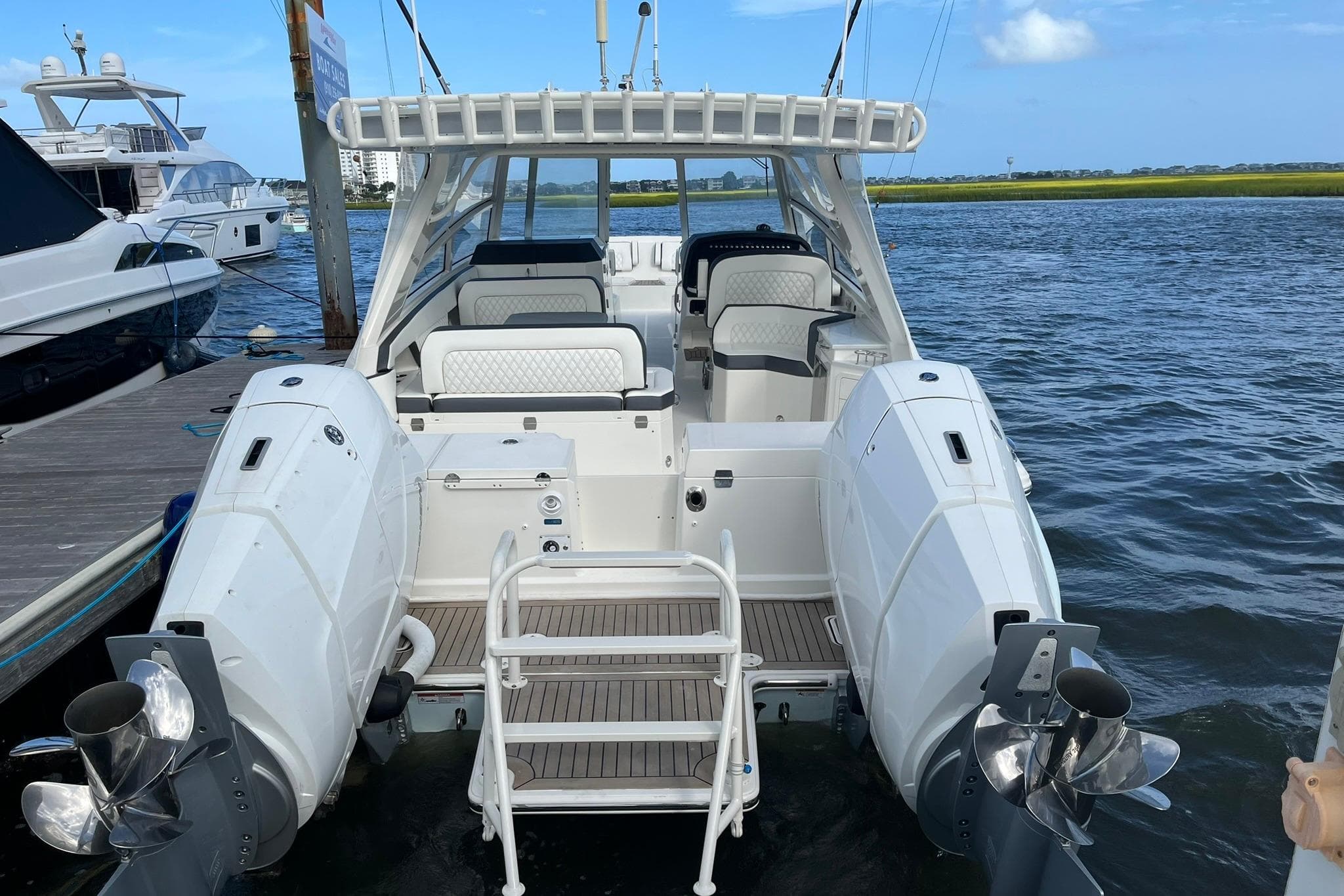 2023 World Cat 400 DC-X boat docked, showcasing spacious seating and dual outboard engines.