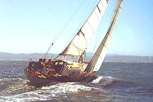 1965 Pearson Vanguard sailboat navigating open waters with crew on board.