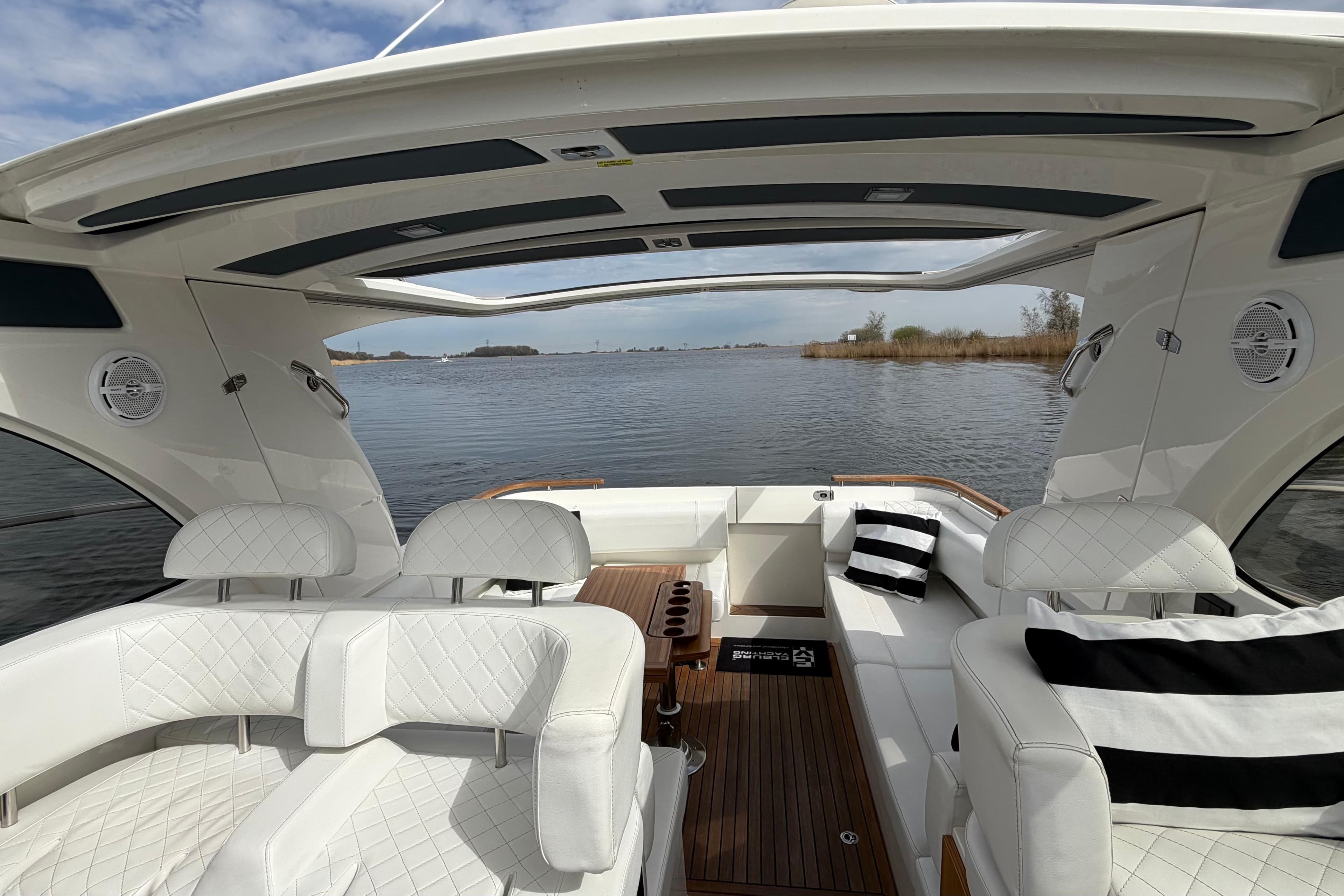 Luxurious interior of 2020 Marex 310 Sun Cruiser with white seating and panoramic water view.