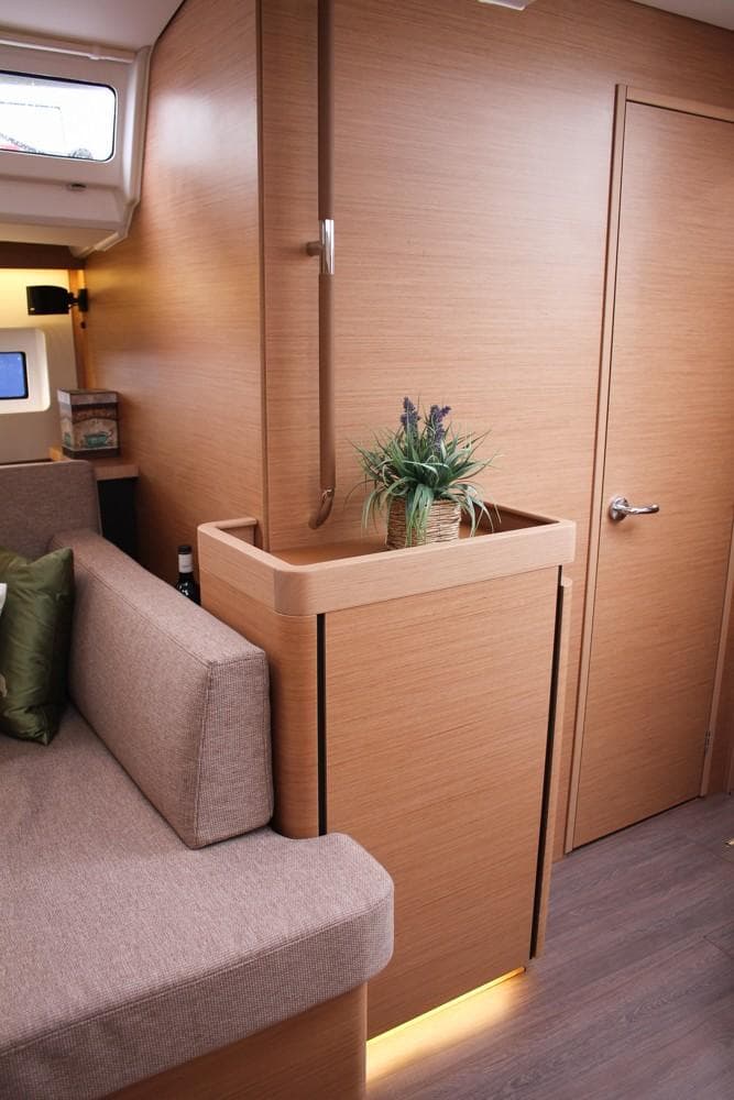 2025 Jeanneau Sun Odyssey 440 interior with modern wood finish and cozy seating area.