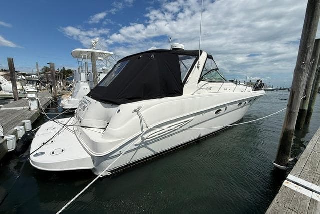 2000 Sea Ray Sundancer 460 yacht docked at marina under partly cloudy sky.