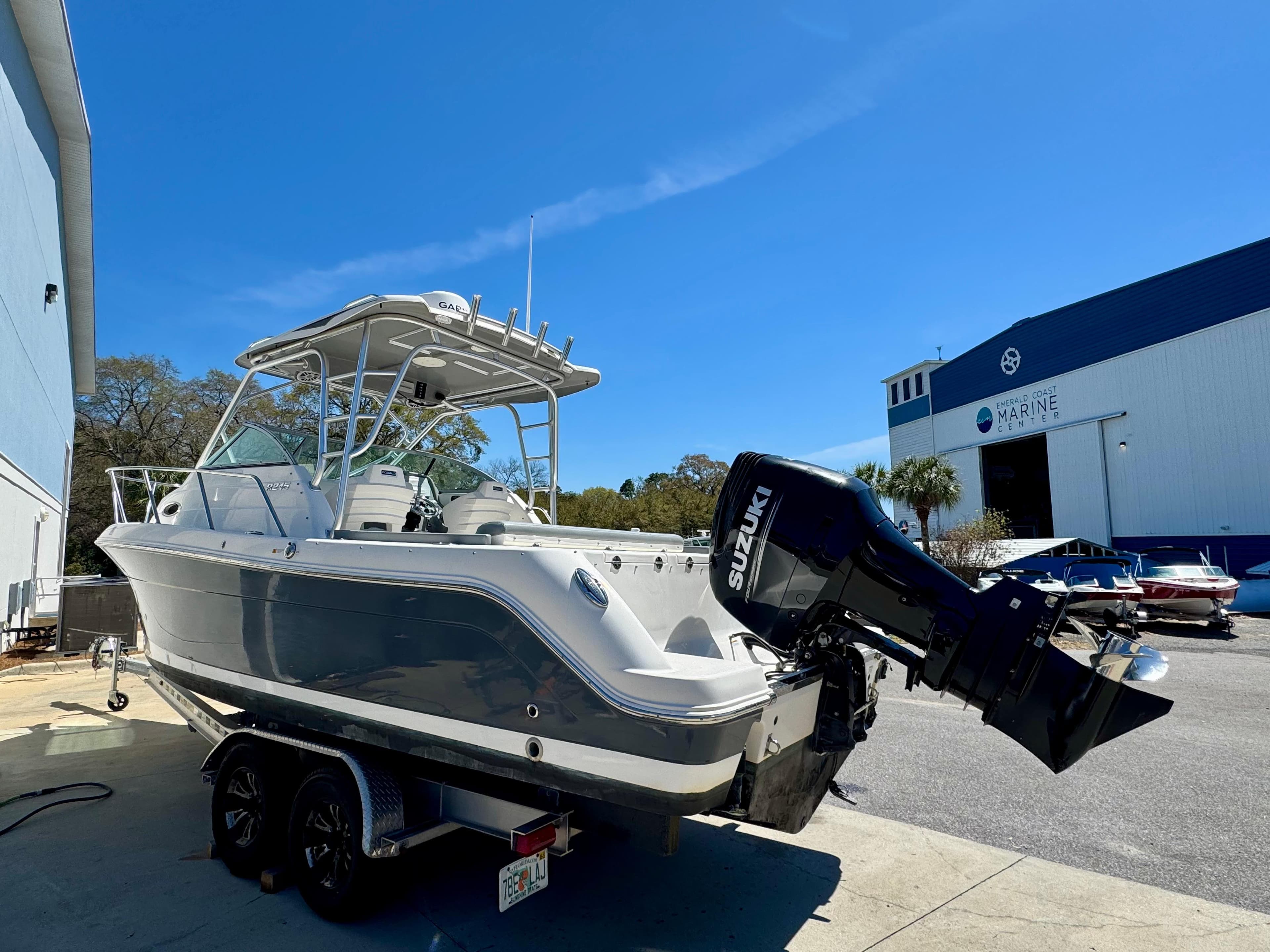 2015 Robalo R245 Walkaround boat with Suzuki outboard motor, parked near a marine facility.