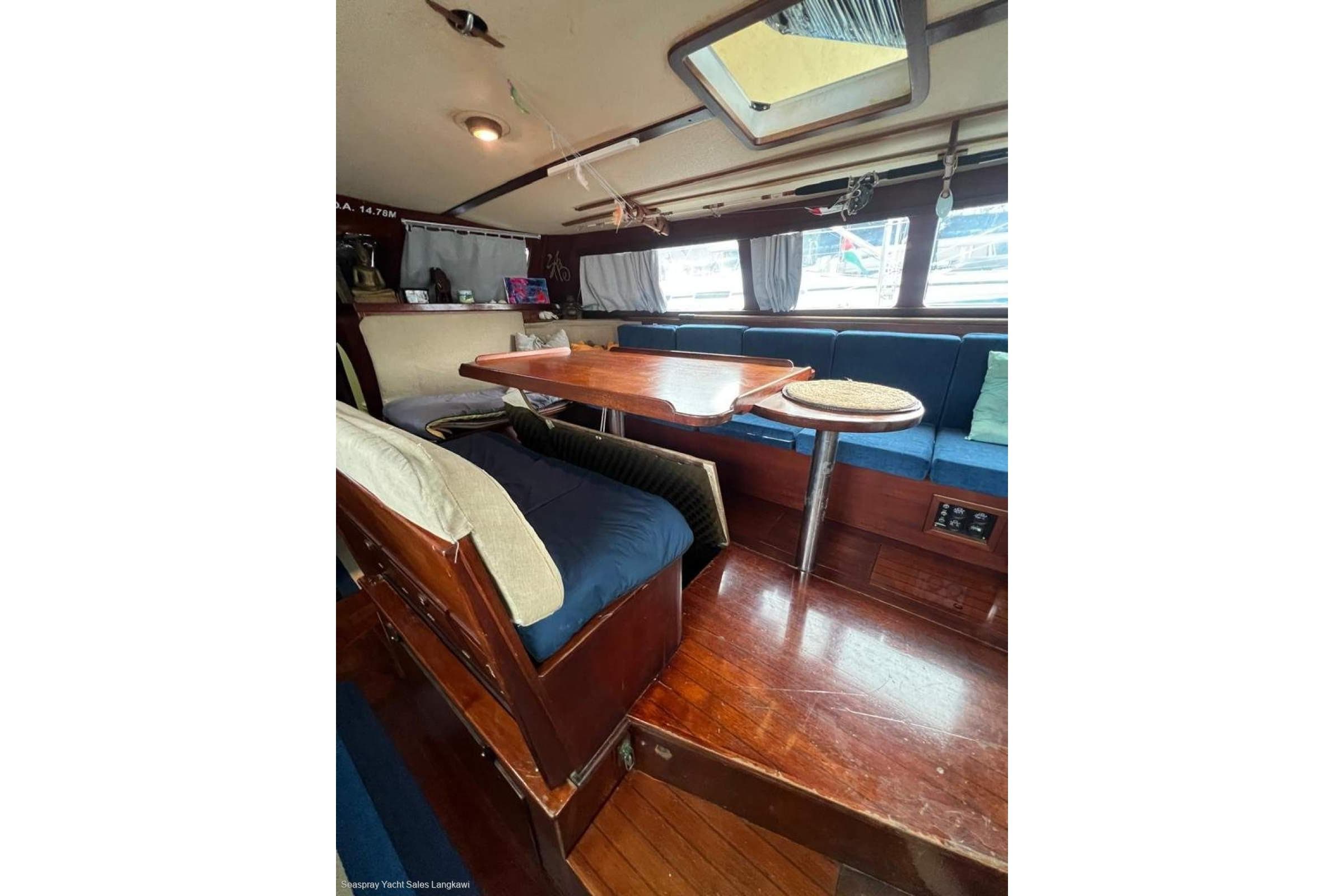 Interior of 1985 Dynamique Express 52 yacht with wooden flooring and cozy seating area.