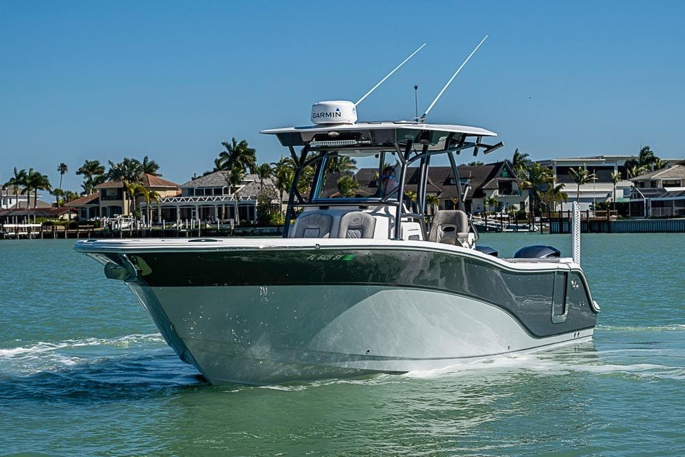 2018 Sea Fox 328 Commander boat cruising on a sunny day near waterfront homes.