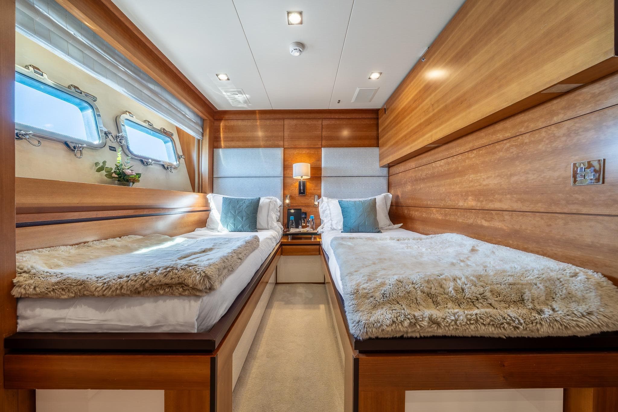 Luxurious twin cabin interior on 2011 Guy Couach 121' yacht, featuring elegant wood paneling.