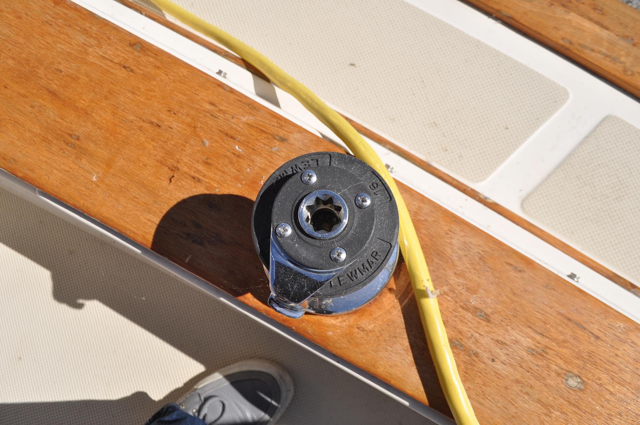 Winch on 1989 Island Packet 27 sailboat deck with yellow rope.