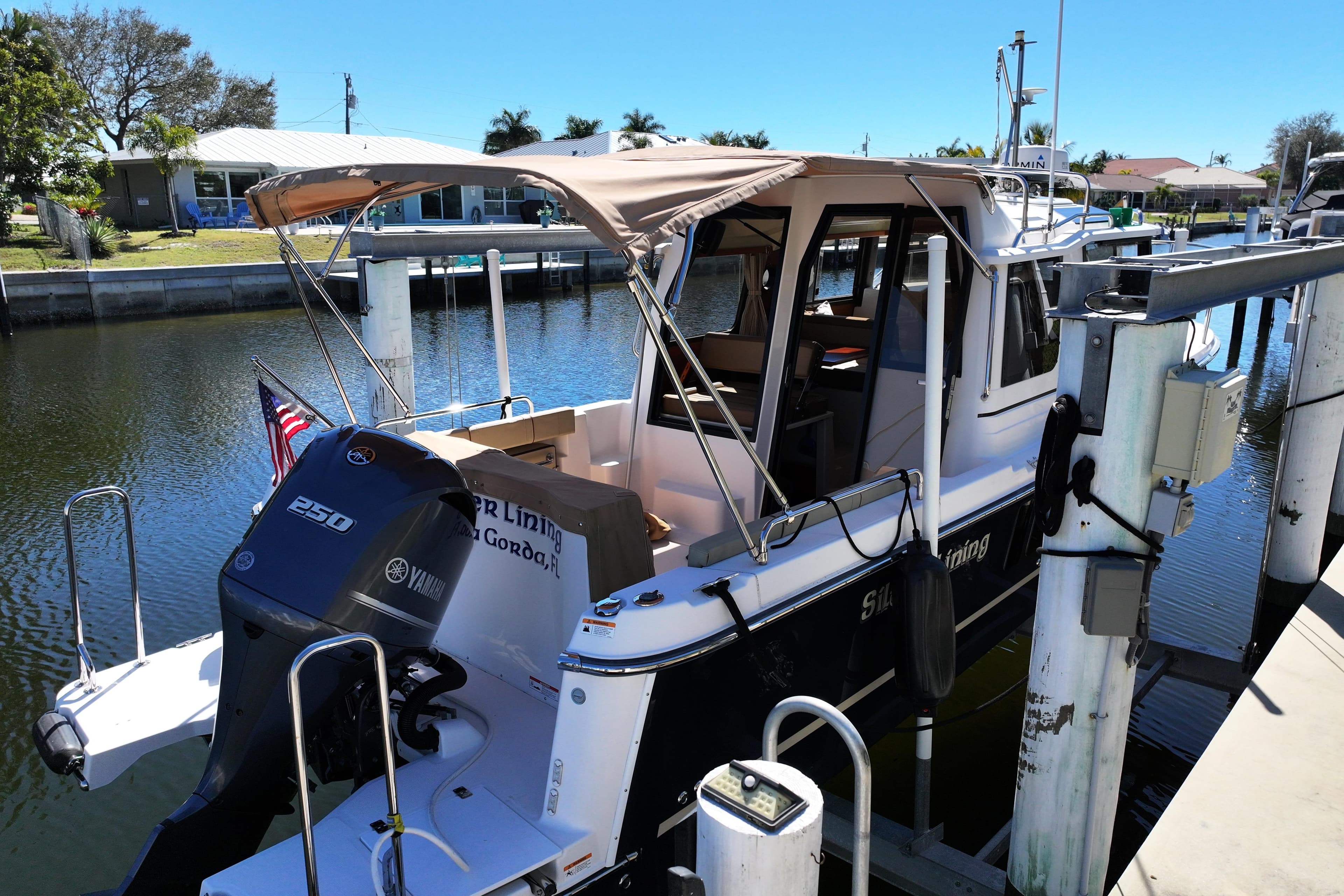 2020 Ranger Tugs R-25 docked, featuring Yamaha 250 engine, in a sunny marina setting.