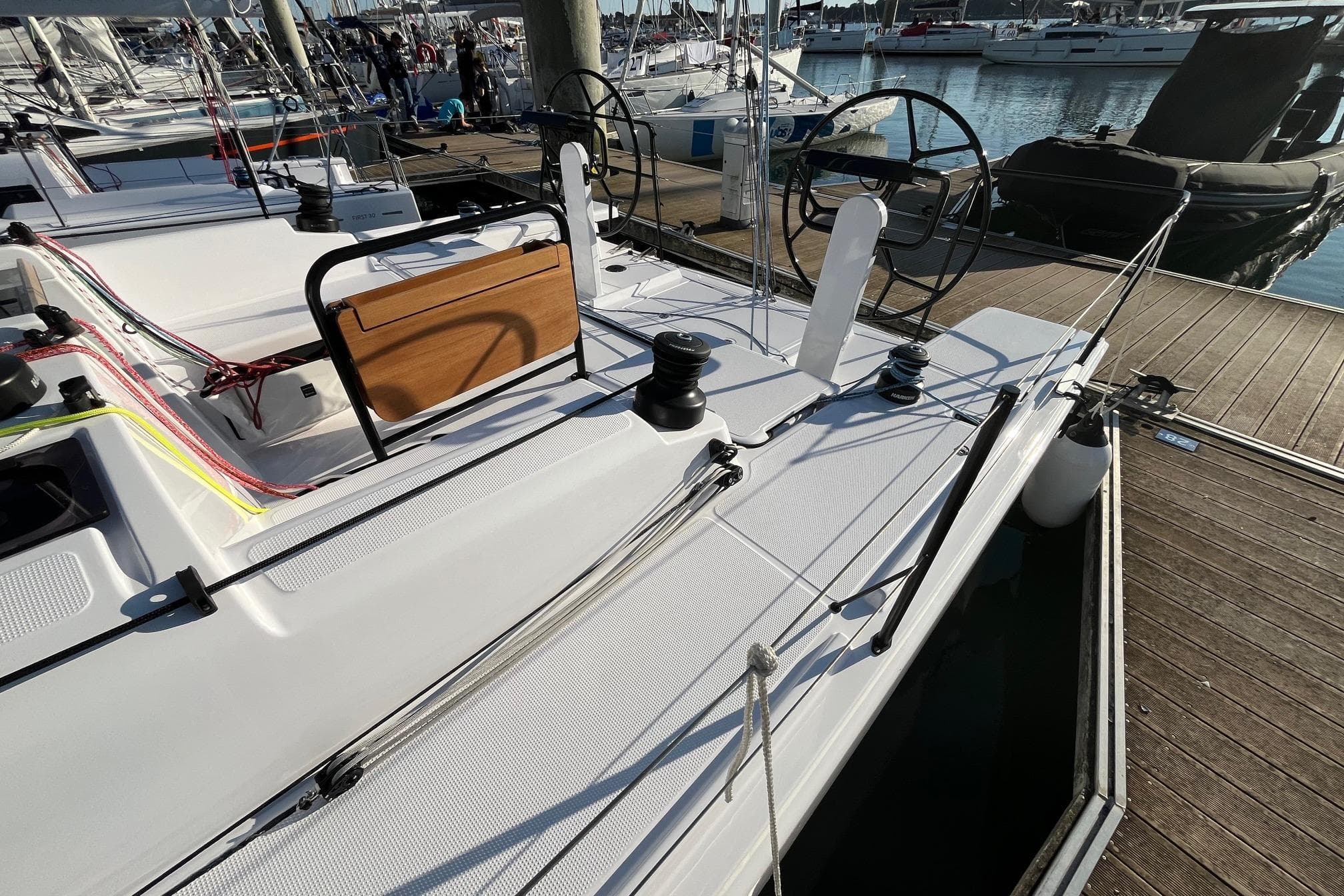 2025 Beneteau First 36 sailboat docked, showcasing sleek deck design and dual steering wheels.