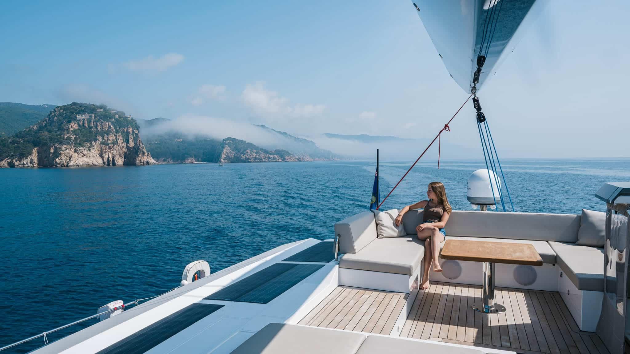 Luxury sailing on 2025 Privilege Signature 580 yacht, scenic coastal view.