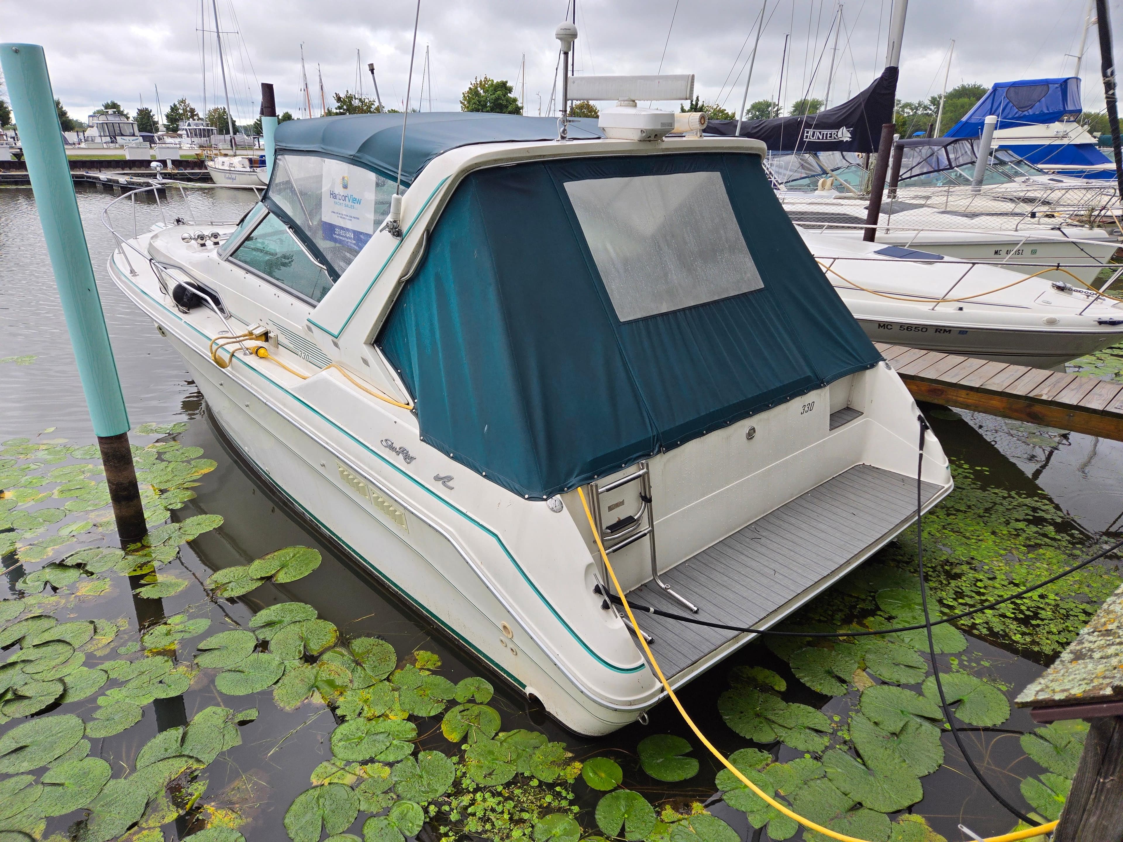 1993 Sea Ray 330 Express Cruiser docked in a marina, surrounded by lily pads.