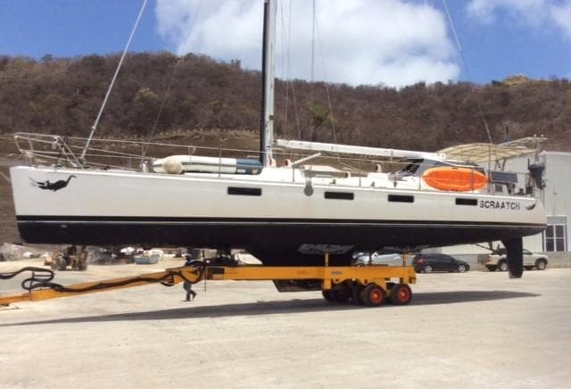 Sundeer 56 sailboat from 1994 on a trailer, set against a mountainous backdrop.