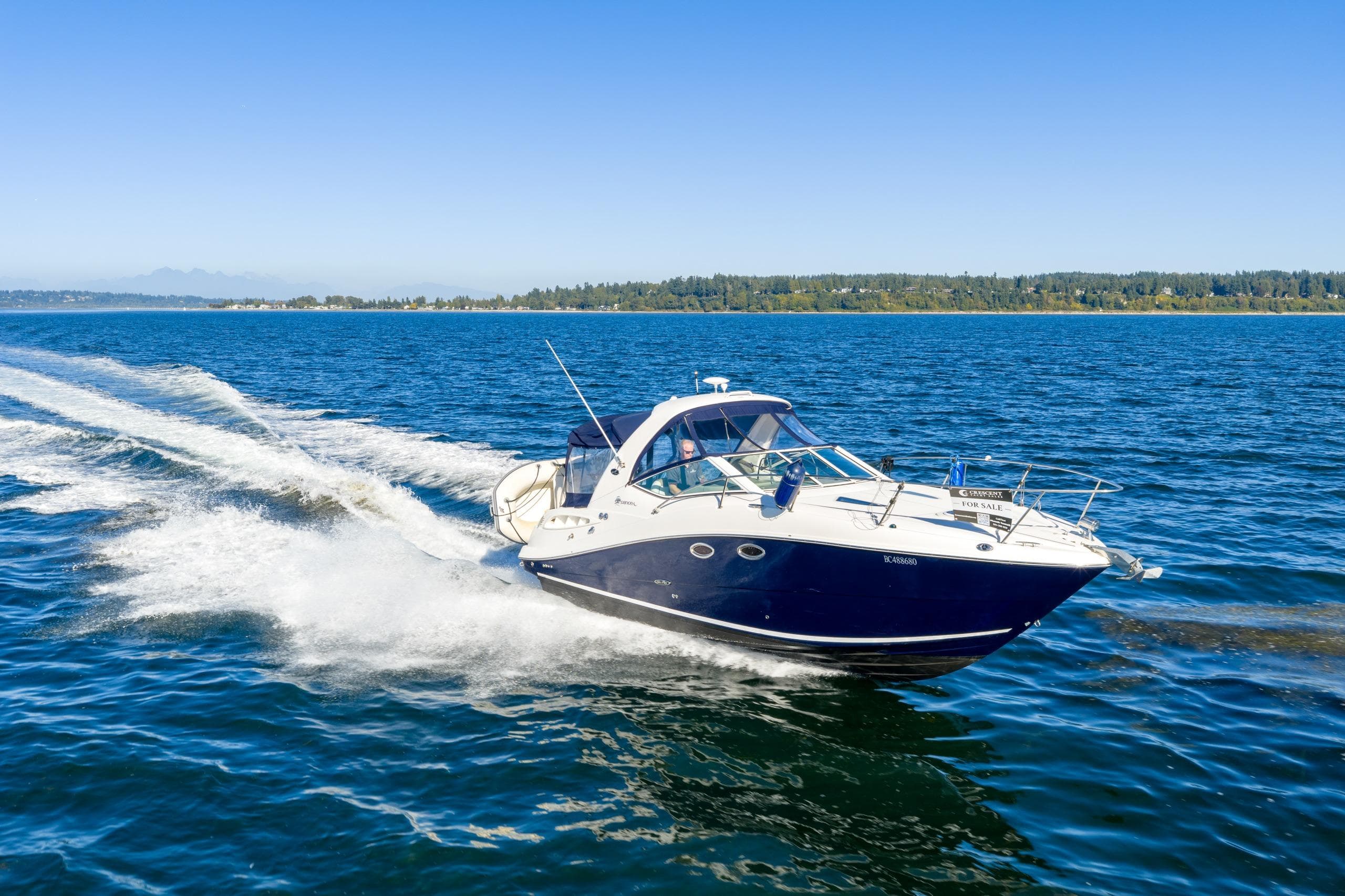 2006 Sea Ray 290 Sundancer cruising on open water under clear blue skies.