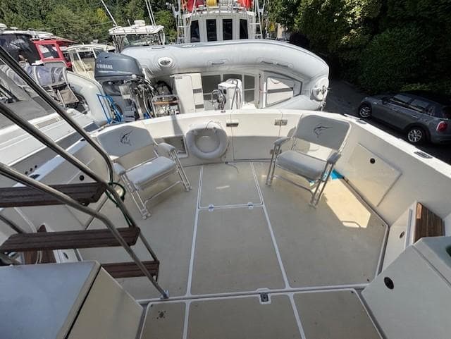 1988 Riviera Convertible boat deck with chairs and equipment, docked near other vessels.