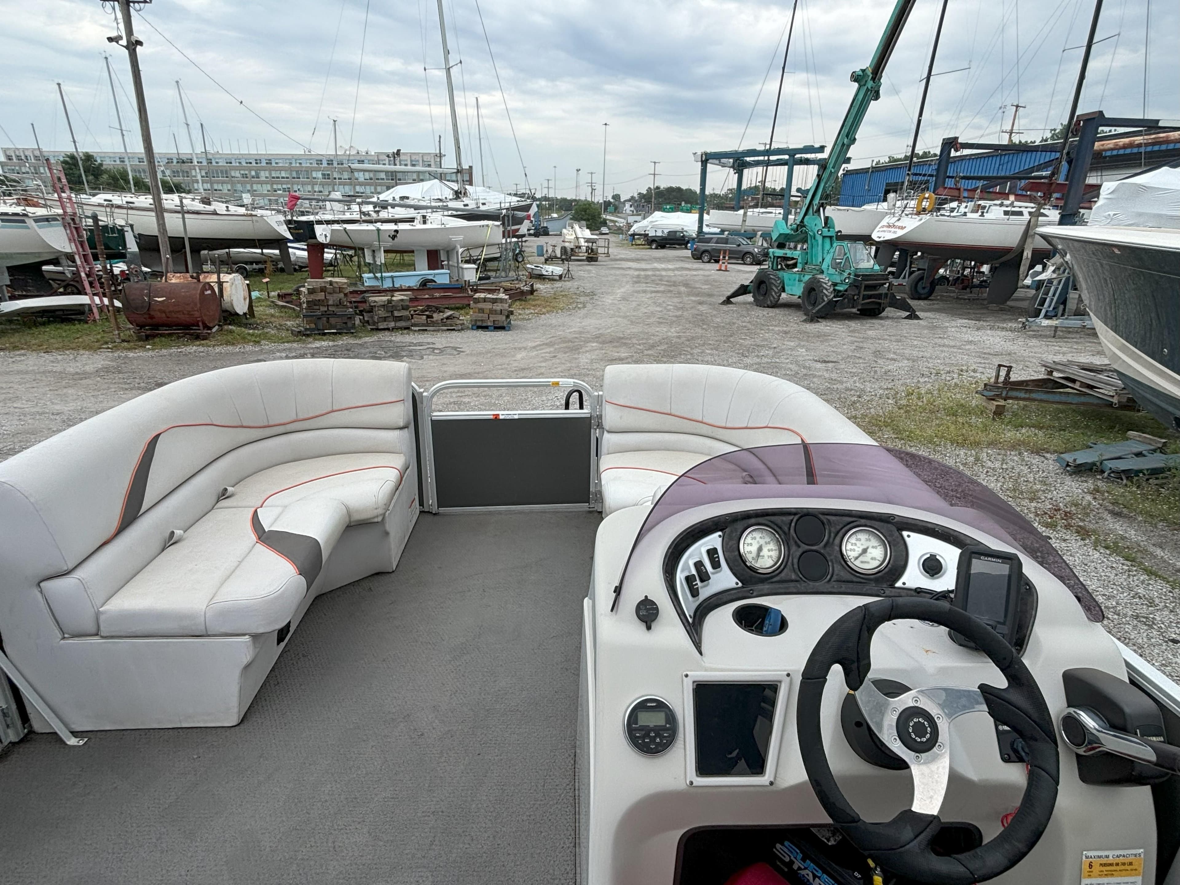 2018 SunCatcher V16 Cruise pontoon boat interior with steering console and seating, docked at marina.