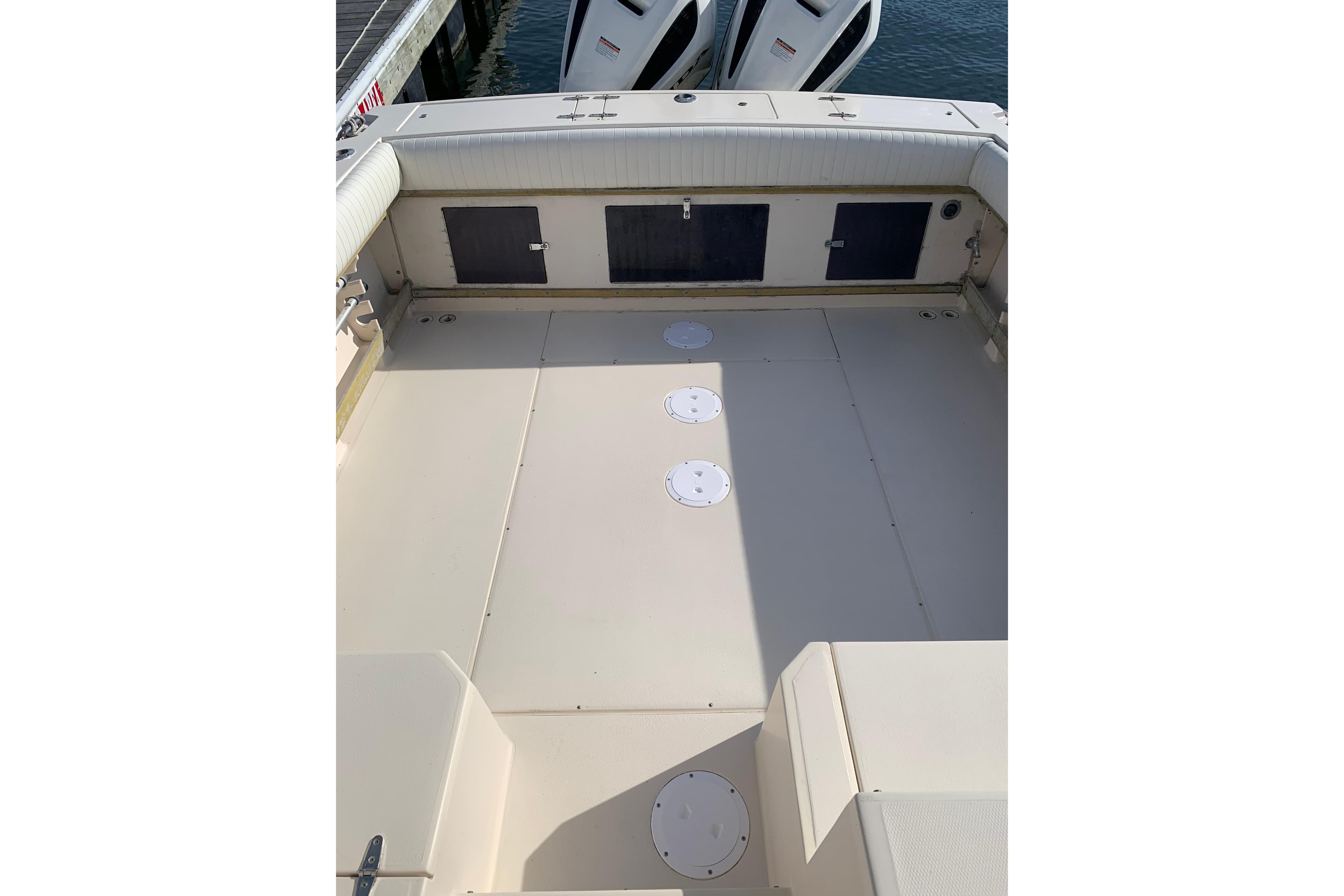1992 Grady-White Dolphin 251 boat deck with storage compartments and twin outboard motors.