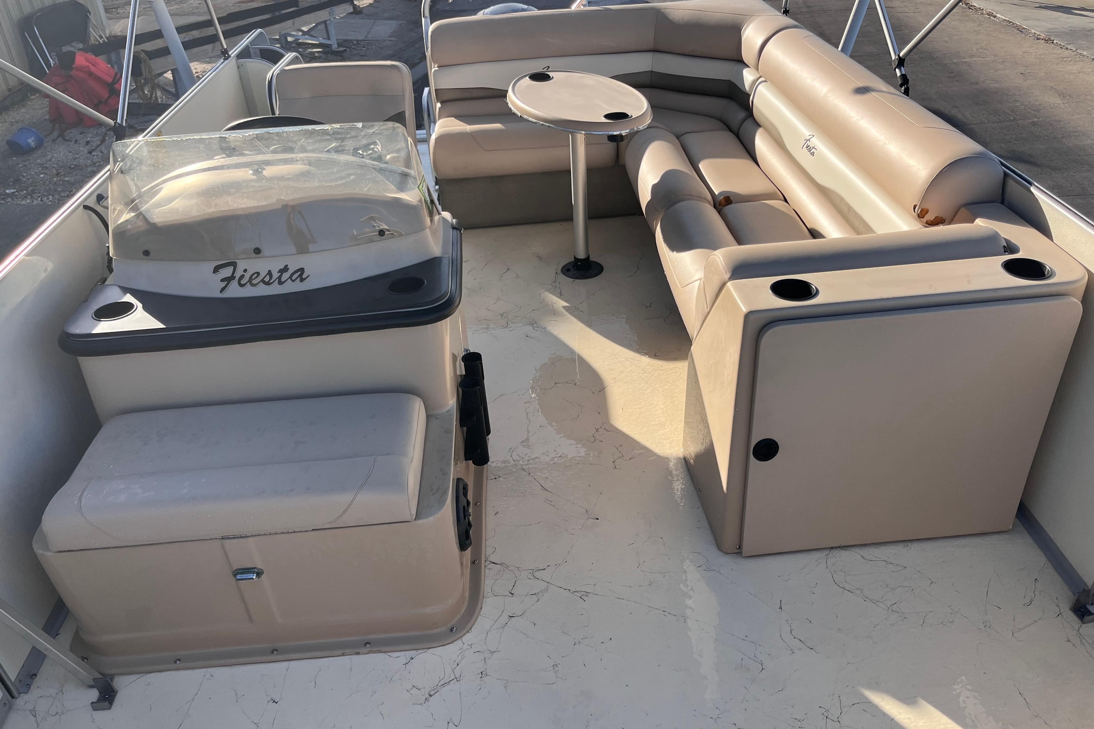 2017 Fiesta 22 Beachcomber boat interior with beige seating and table.