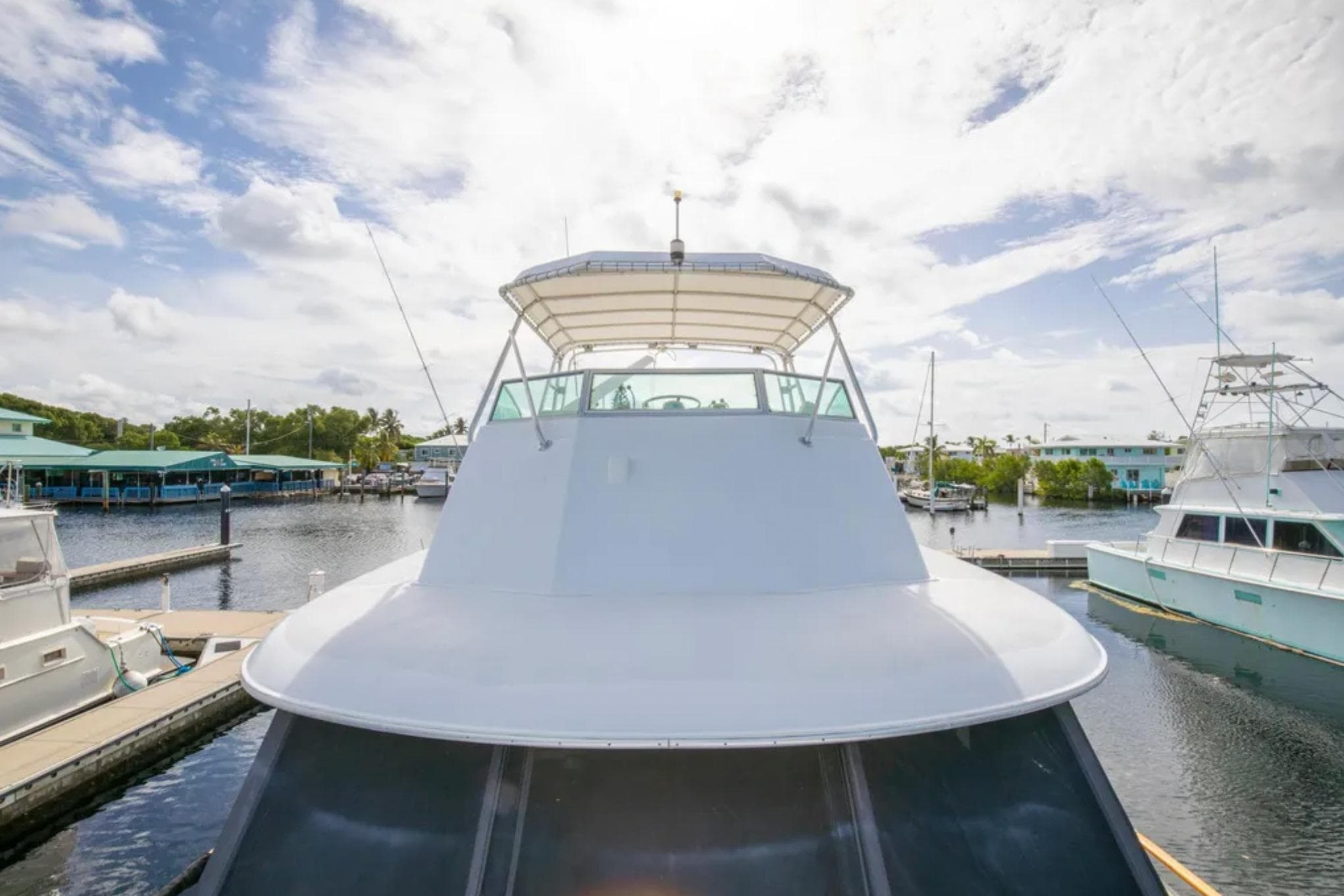 1973 Hatteras 58 Yacht Fisherman docked in a sunny marina setting.