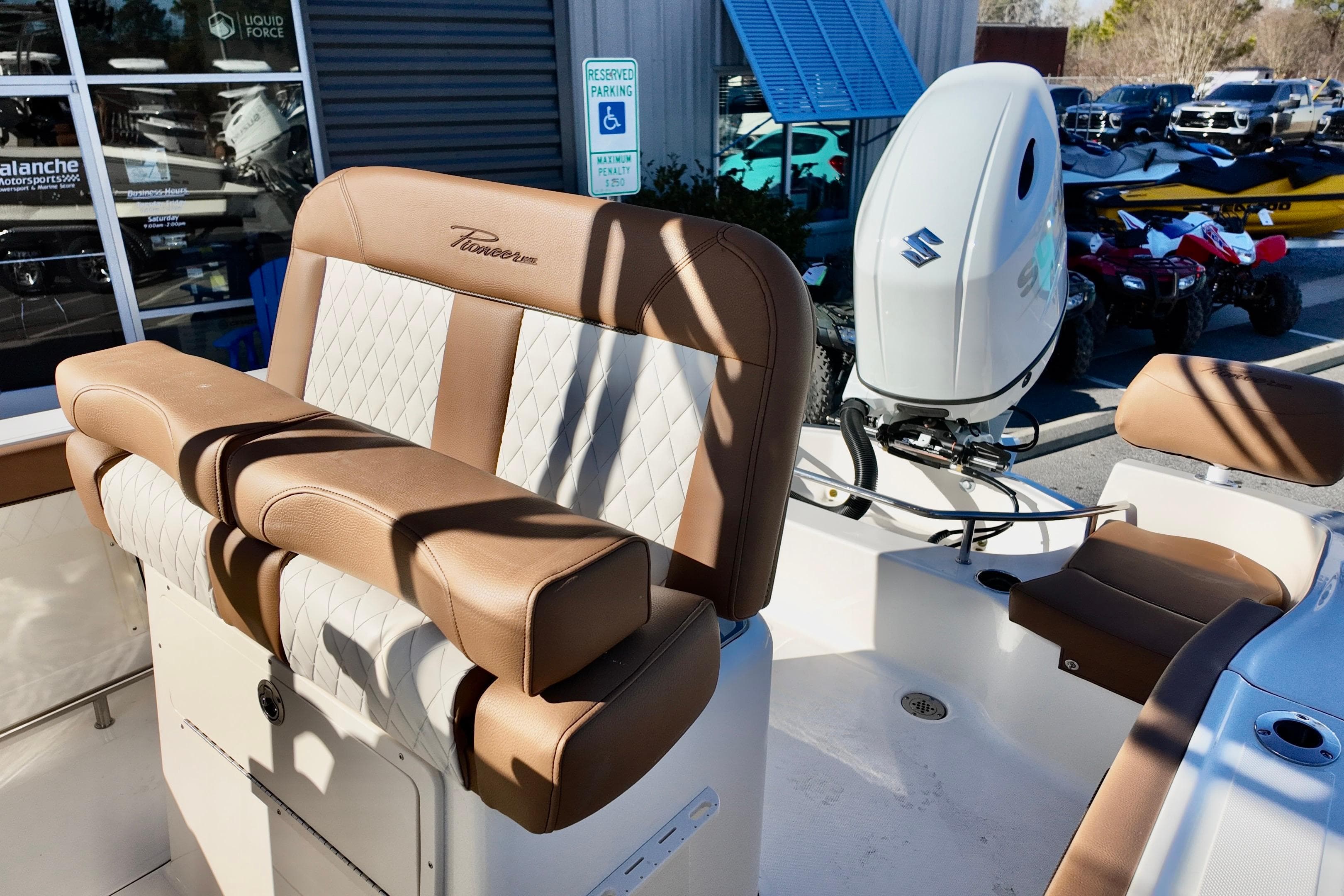 2026 Pioneer 202 Sportfish boat interior with brown and white seating, Suzuki outboard motor.