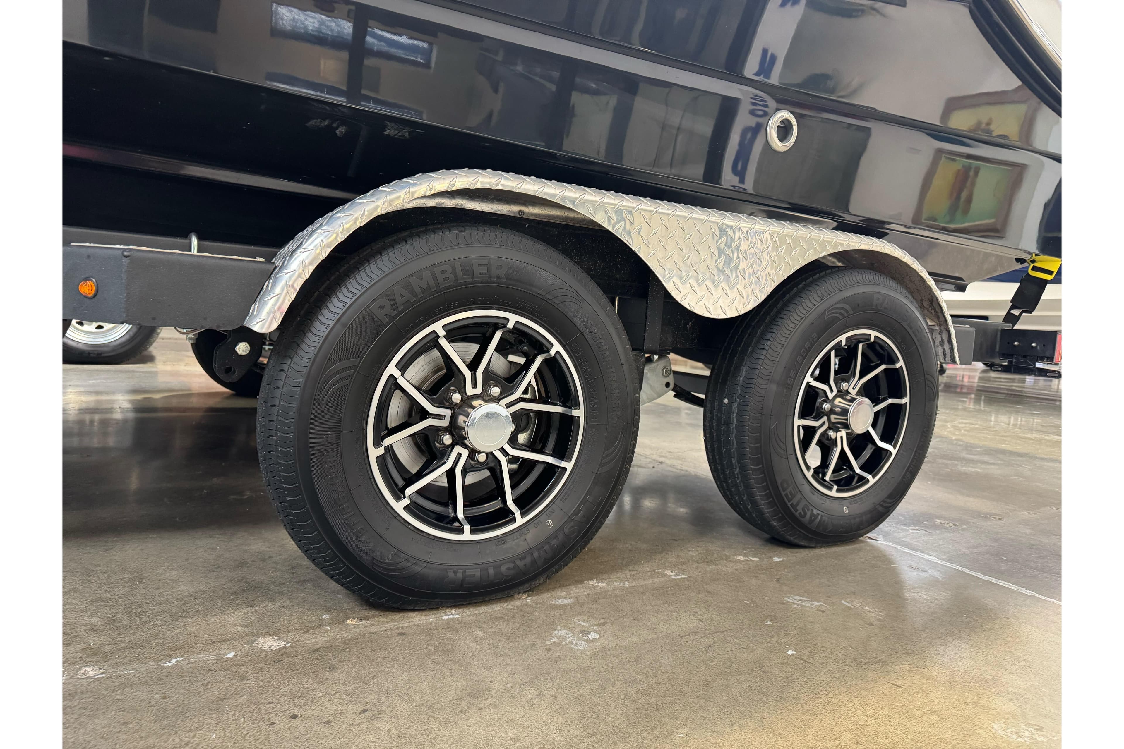Trailer wheels of a 2026 Sea Ray SPX 210 boat, featuring black alloy rims.