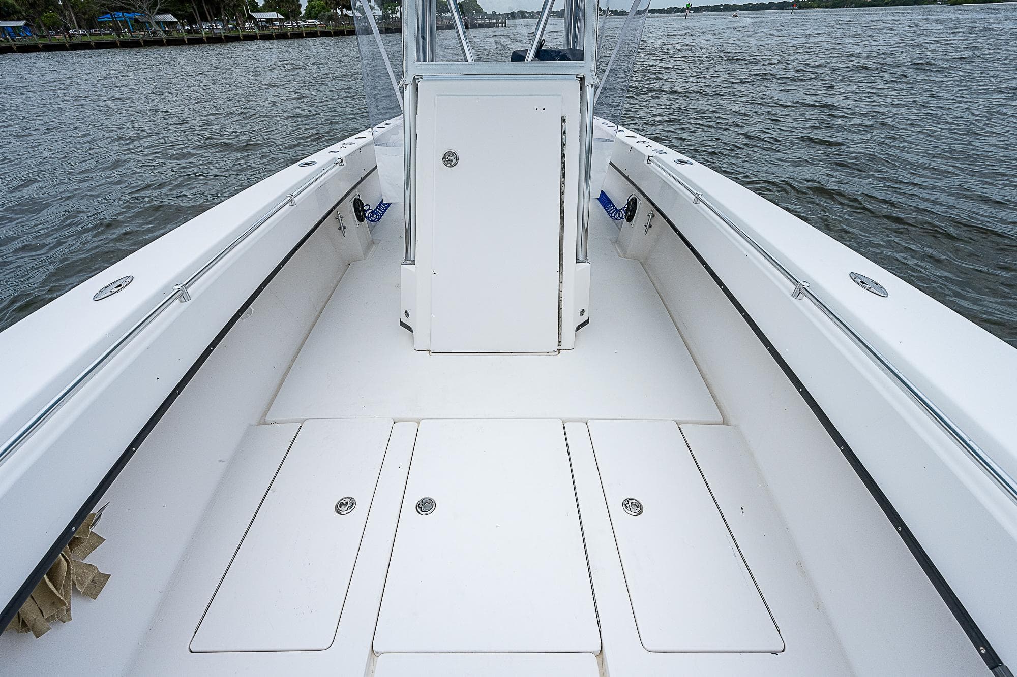 2004 Contender 36 Open boat deck with storage compartments on a calm water body.