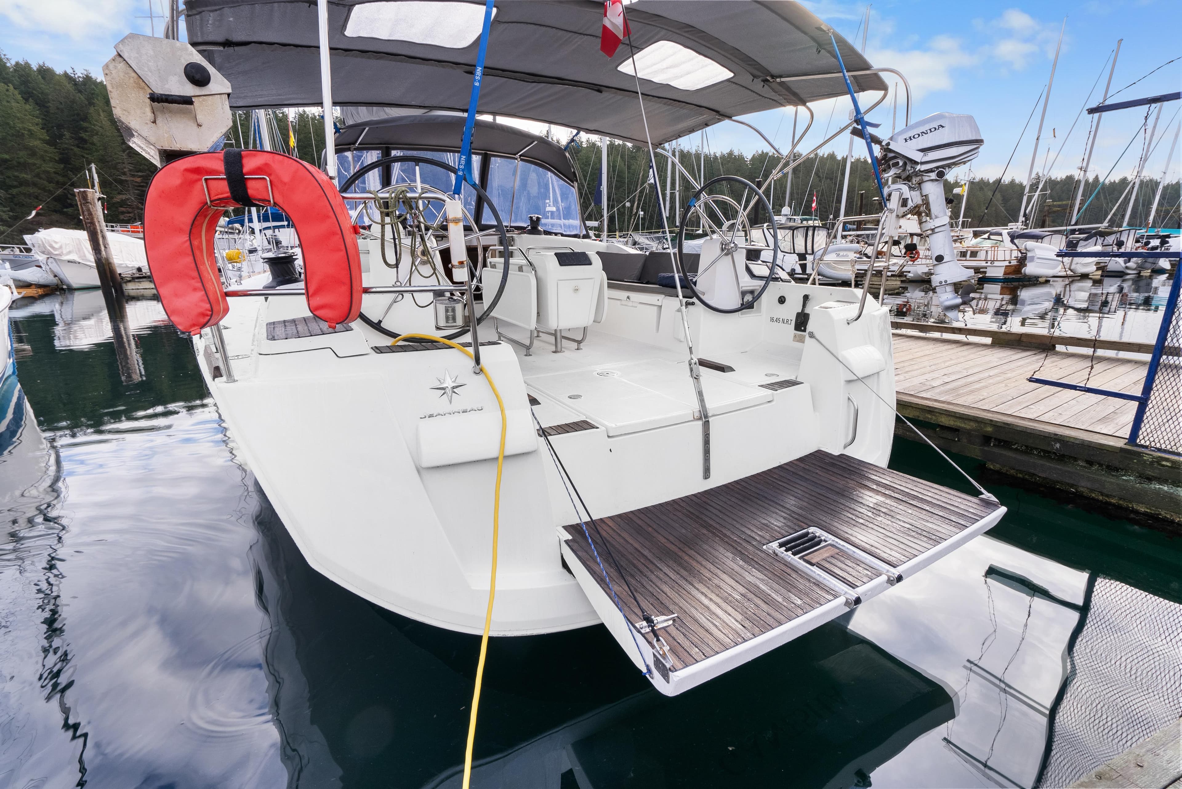 2015 Jeanneau Sun Odyssey 509 yacht docked, featuring spacious deck and dual steering wheels.
