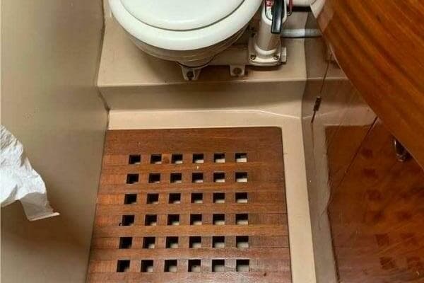 1984 Beneteau First 42 yacht bathroom with wooden floor and marine toilet.