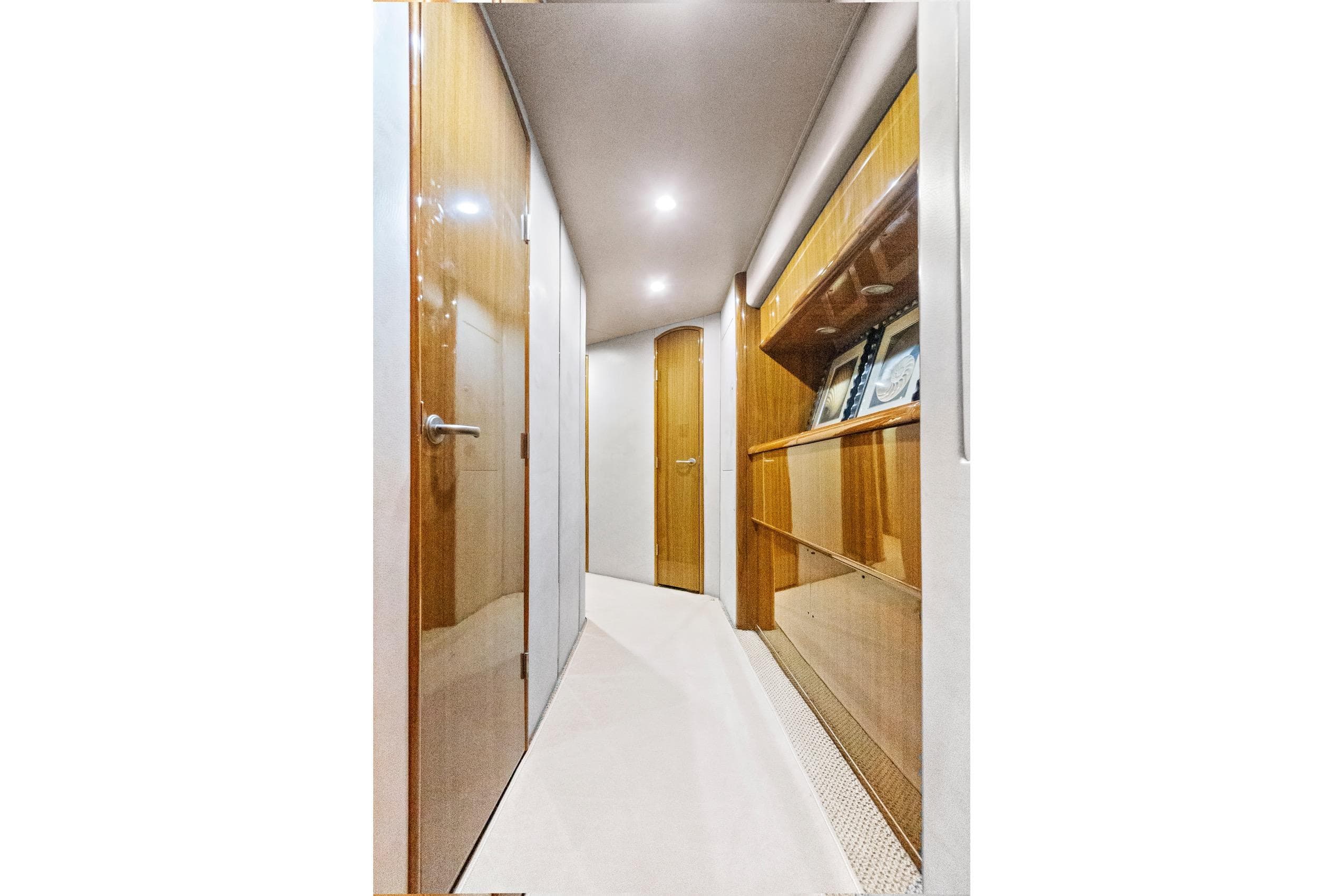 Luxurious hallway interior of 2008 Viking 74 Enclosed Bridge yacht with wooden finishes.