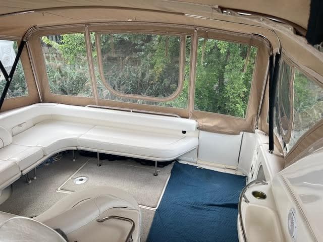 Interior of 1995 Sea Ray 450 Sundancer with white seating and large windows.