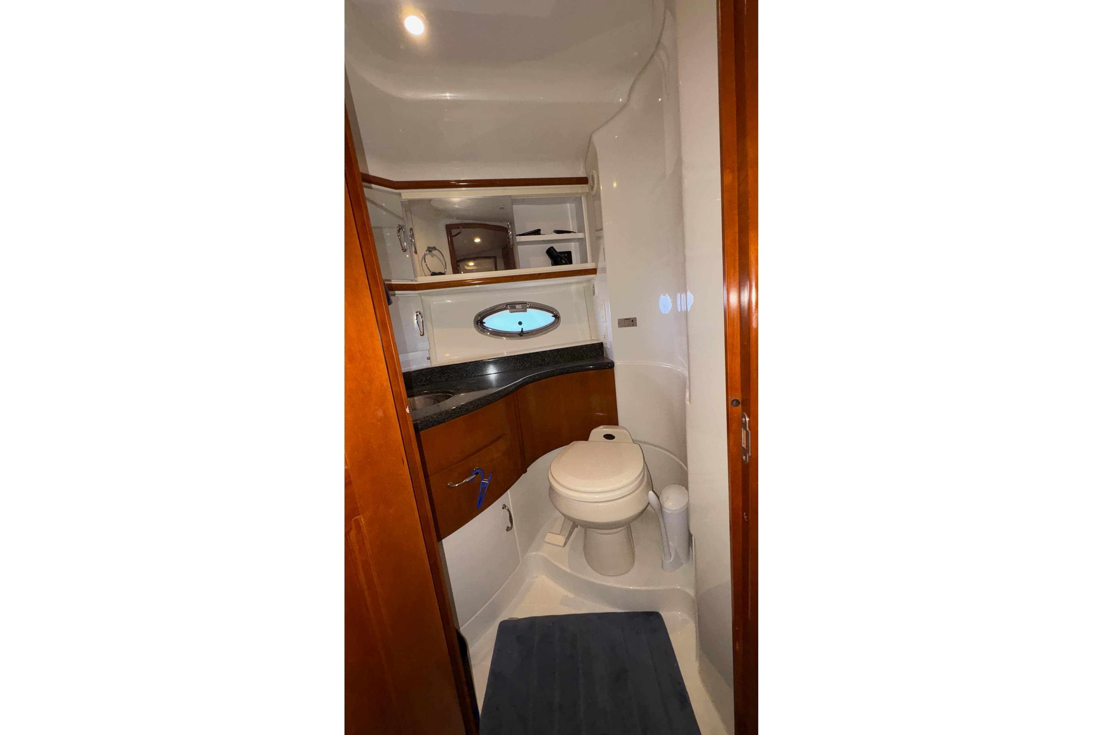 2003 Carver 396 Motor Yacht bathroom with wood accents and porthole window.