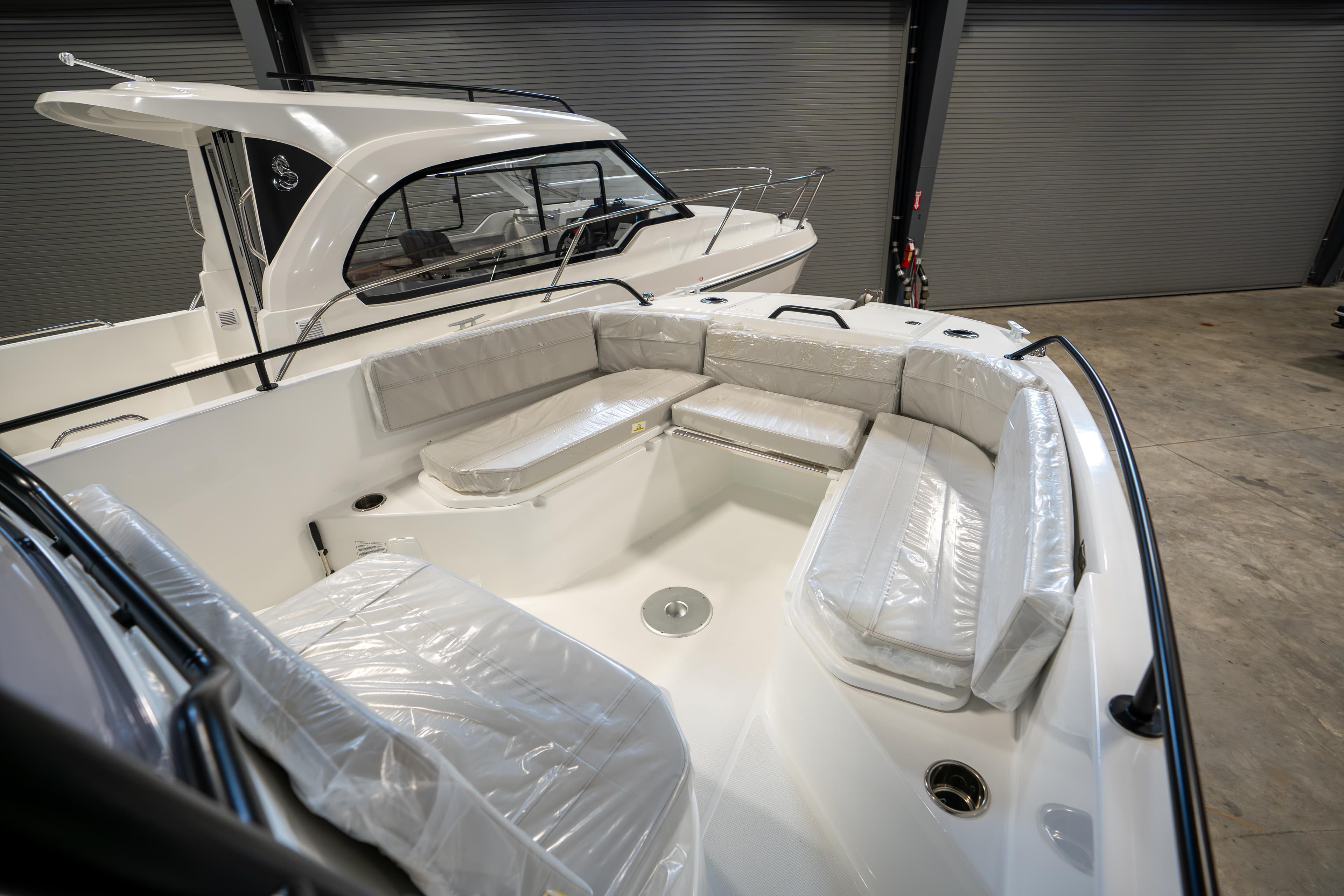 2023 Beneteau Flyer 8 SPACEdeck boat with spacious seating in a showroom.