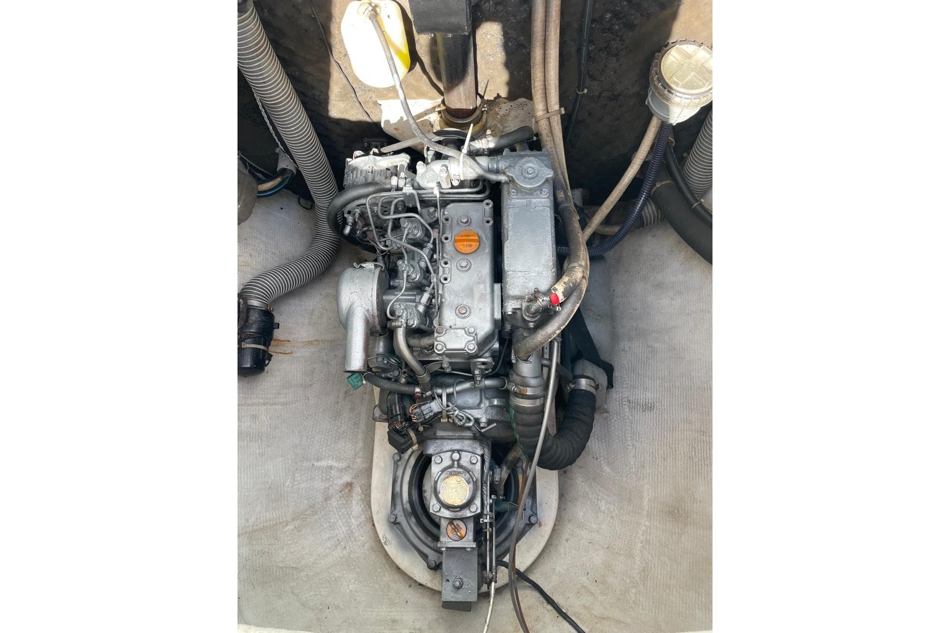Engine compartment of a 2003 Lagoon 380 catamaran, showcasing mechanical components and hoses.