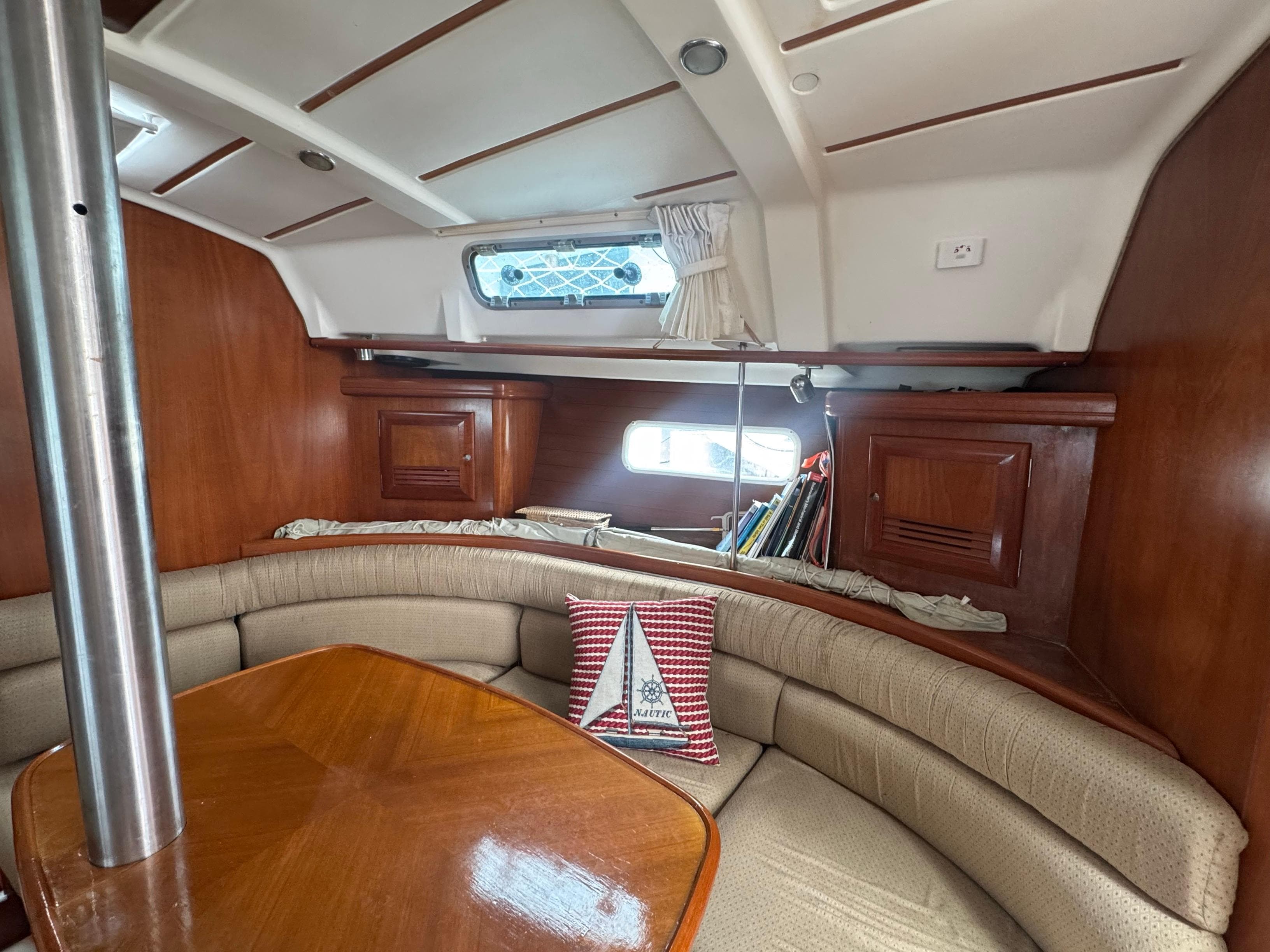 Interior of 2002 Beneteau Oceanis Clipper 361 sailboat with cozy seating and wooden table.