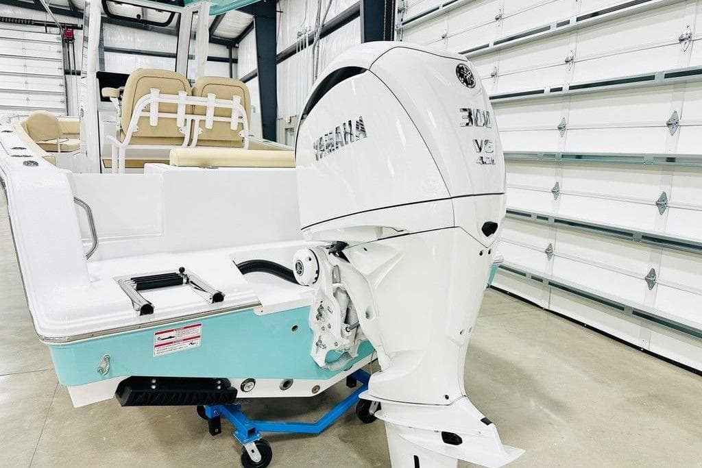 2026 Sportsman Open 232 Center Console boat with powerful outboard motor in a showroom.