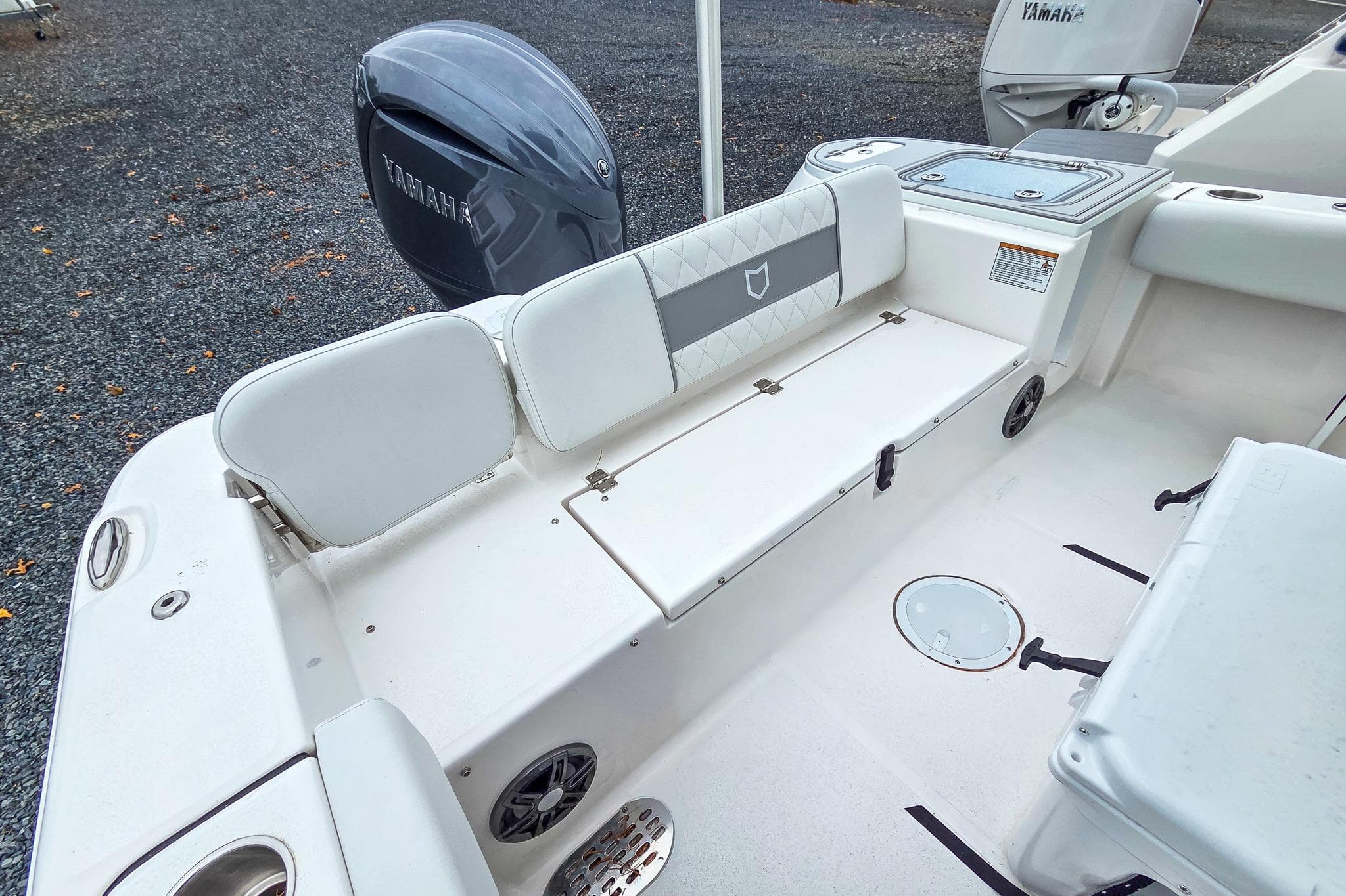 2026 Sea Fox 228 Commander boat interior with Yamaha engine, featuring white seating and storage.