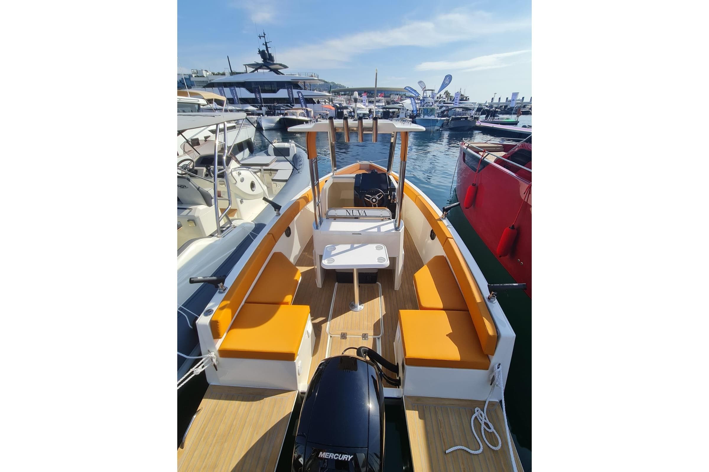 2025 NUVA YACHTS M6 Fisher boat with orange seating, docked at a marina.