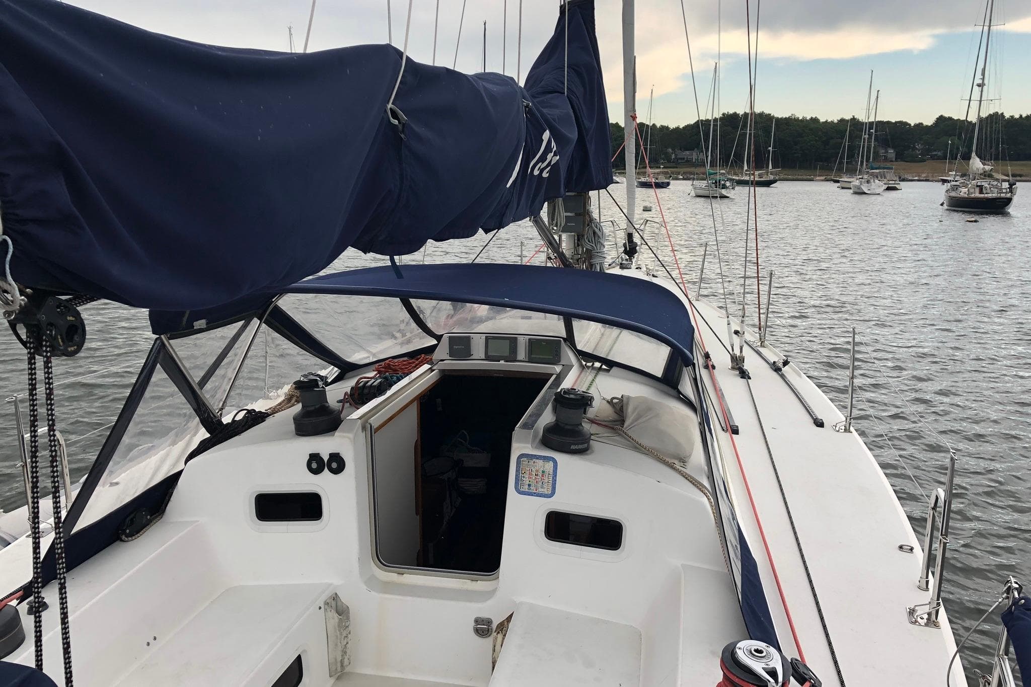 Sailboat J/133 from 2004 docked, featuring a spacious cockpit and blue sail cover.