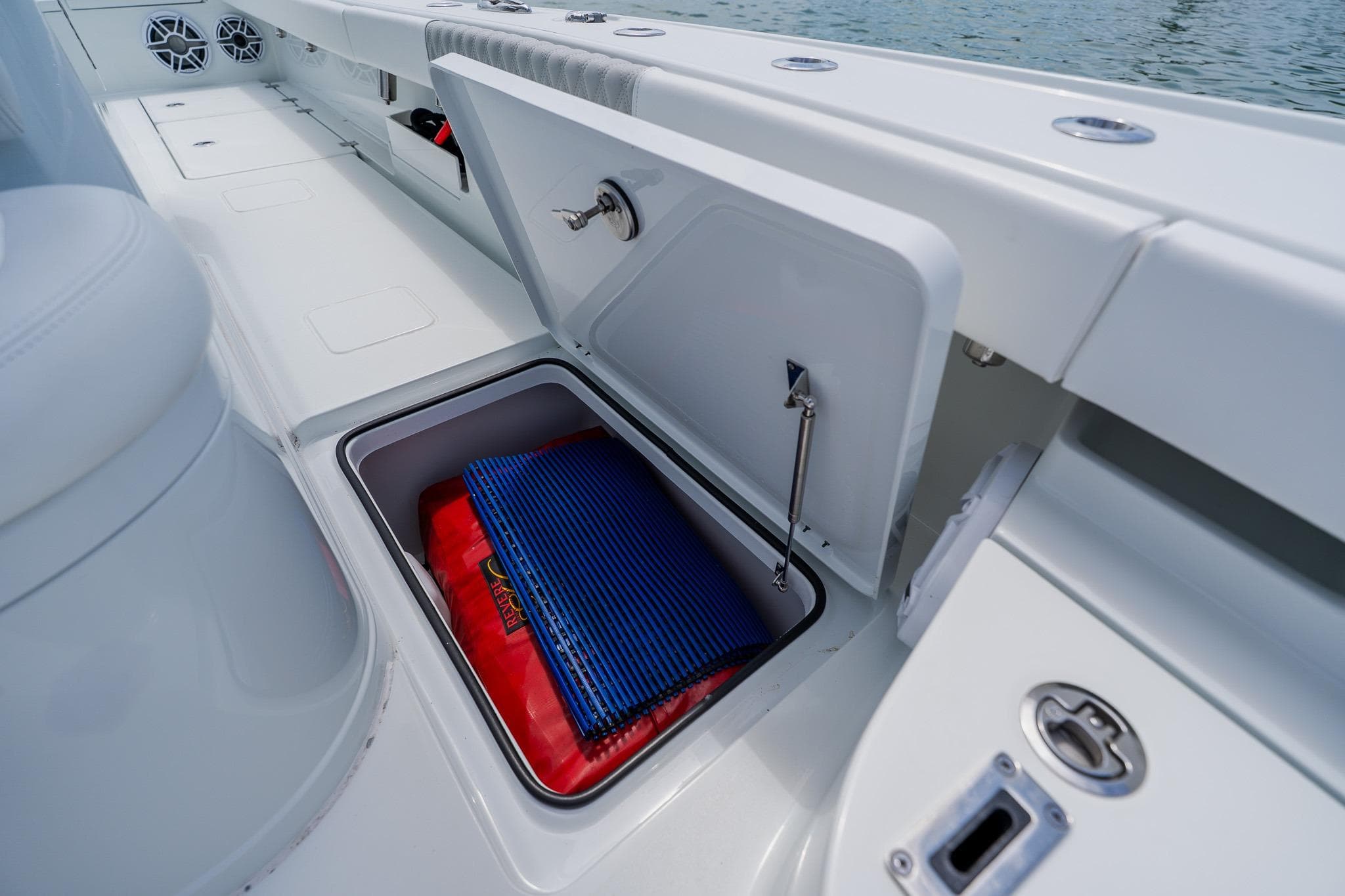 Open storage compartment on a 2023 Freeman 28 boat, featuring marine equipment.