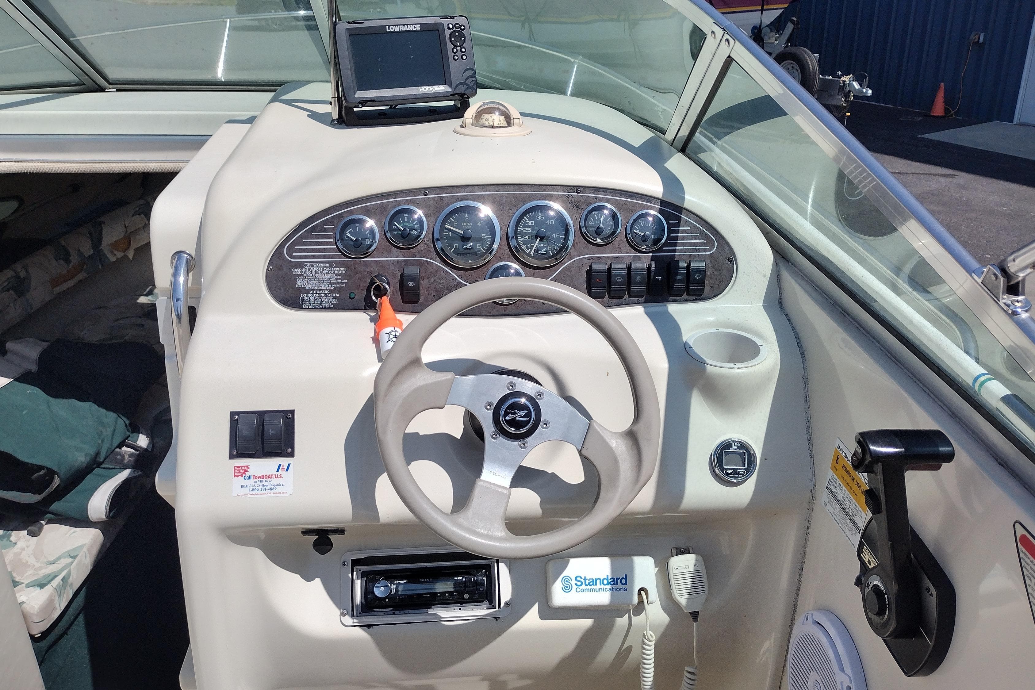 1999 Sea Ray 215 Express Cruiser dashboard with steering wheel and navigation equipment.