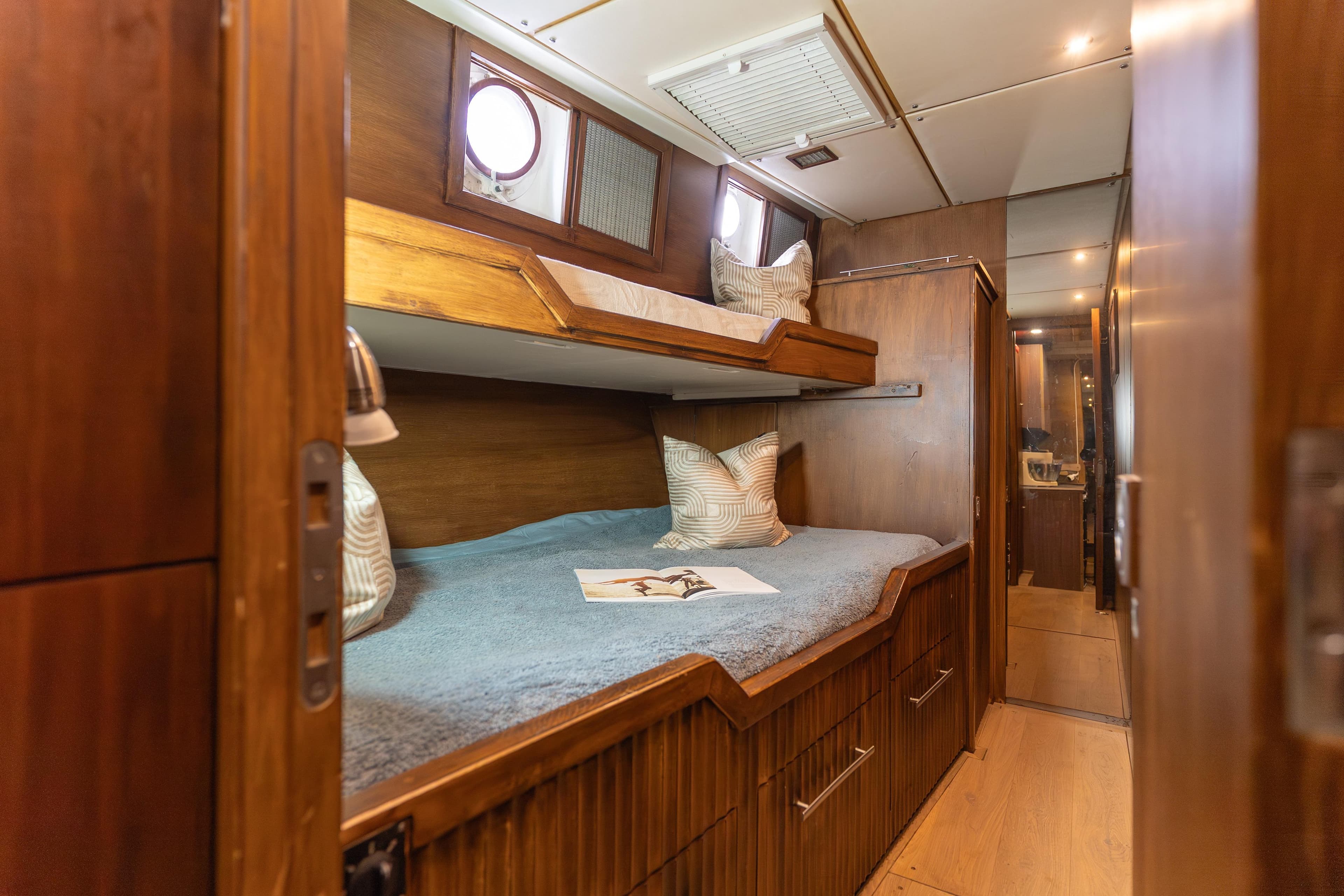 Cozy wooden bunk beds in a 1967 Cammenga 61 yacht cabin interior.
