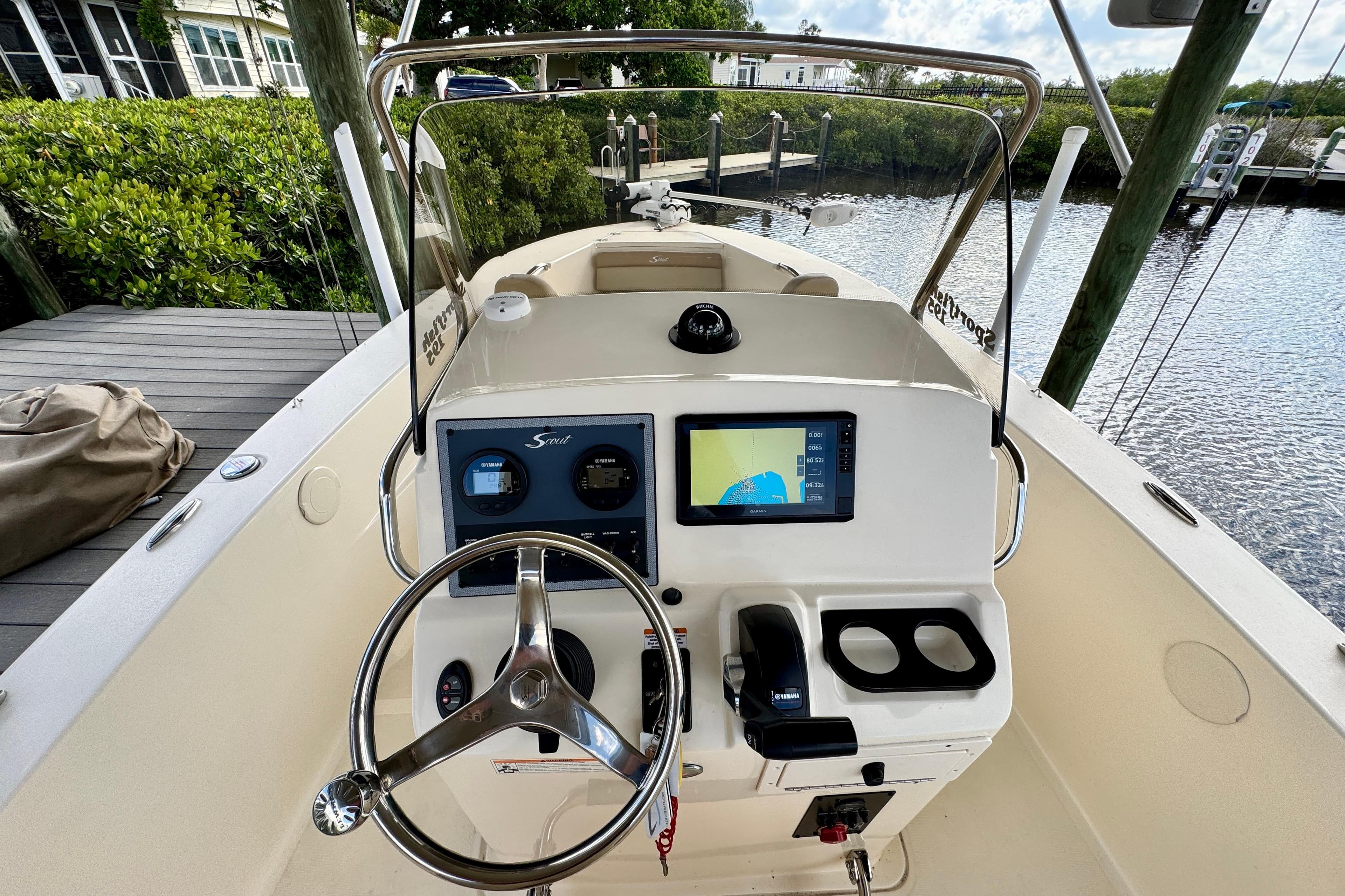 2024 Scout 195 Sportfish boat dashboard with steering wheel and navigation display.