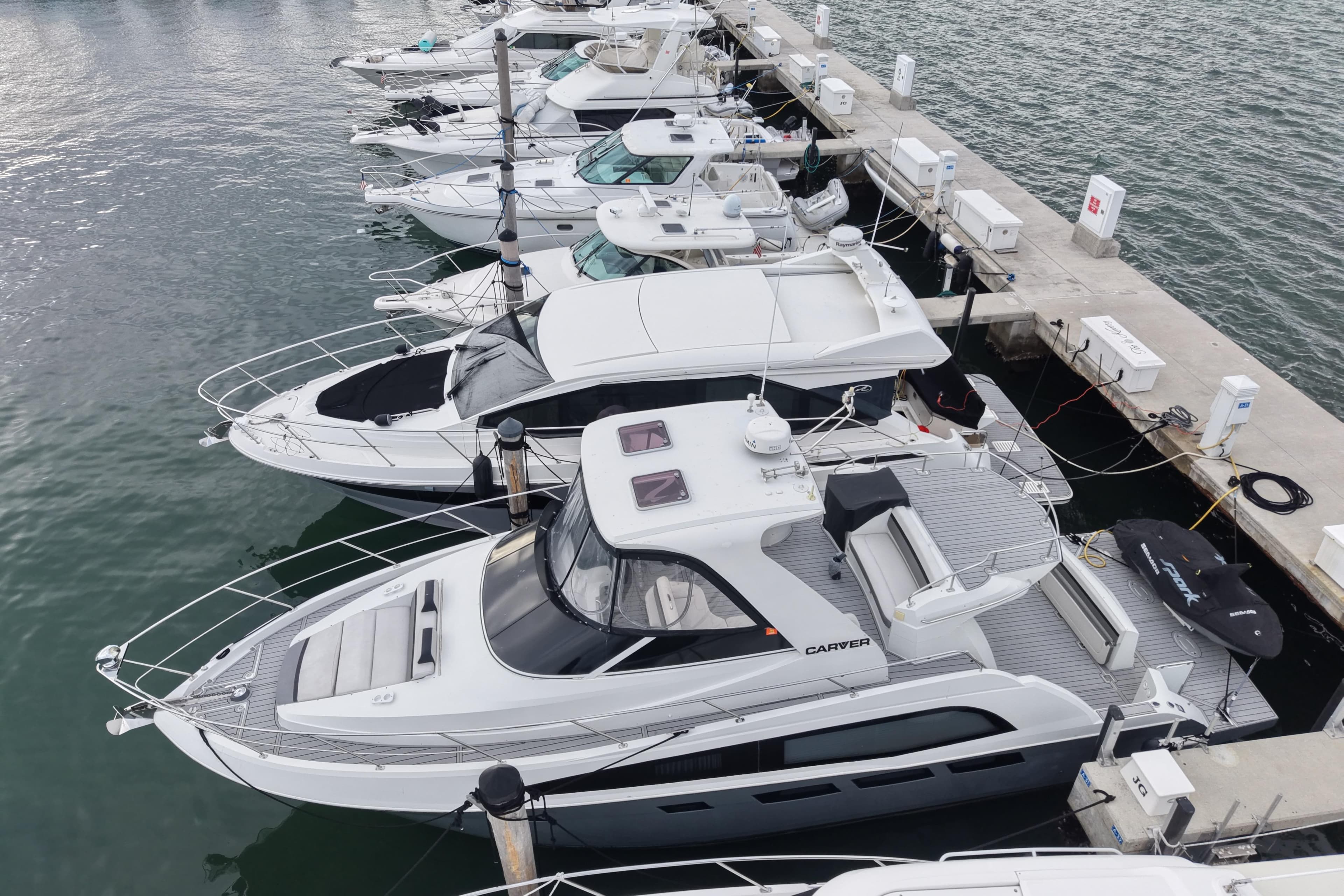 2009 Carver 44 Sojourn yacht docked among other boats in a marina.