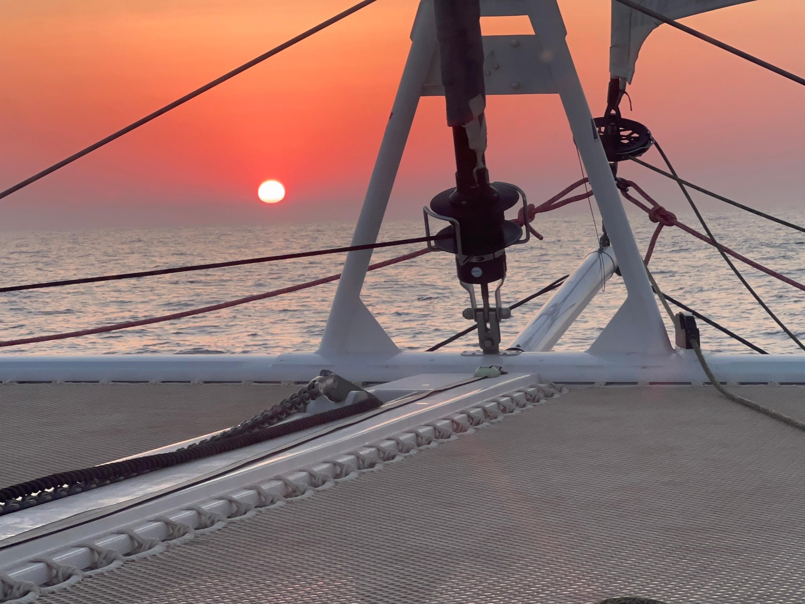 2024 Outremer 45 sailing at sunset, ocean horizon in the background.