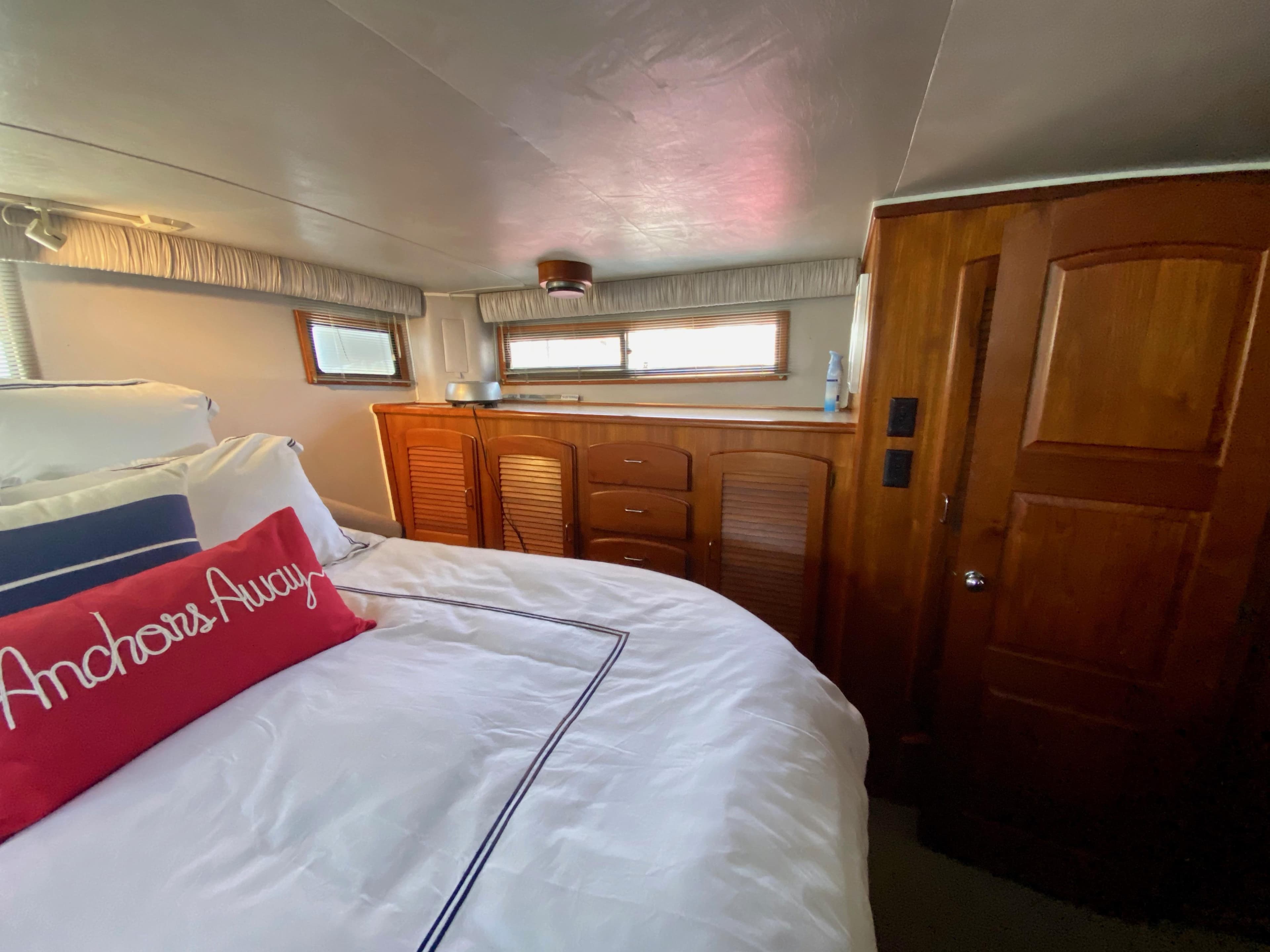 1988 Californian Sundeck Motoryacht bedroom with wooden cabinetry and nautical-themed decor.