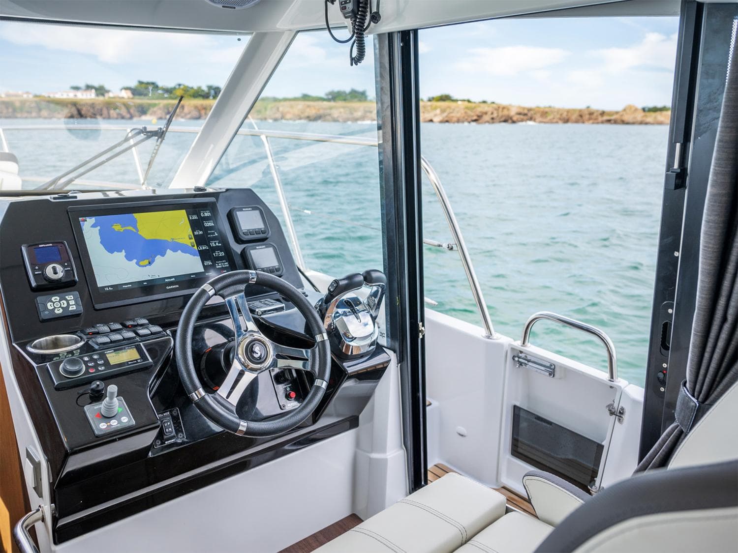 Manufacturer Provided Image: 2025 Beneteau Antares 11 helm with navigation system, steering wheel, and sea view.