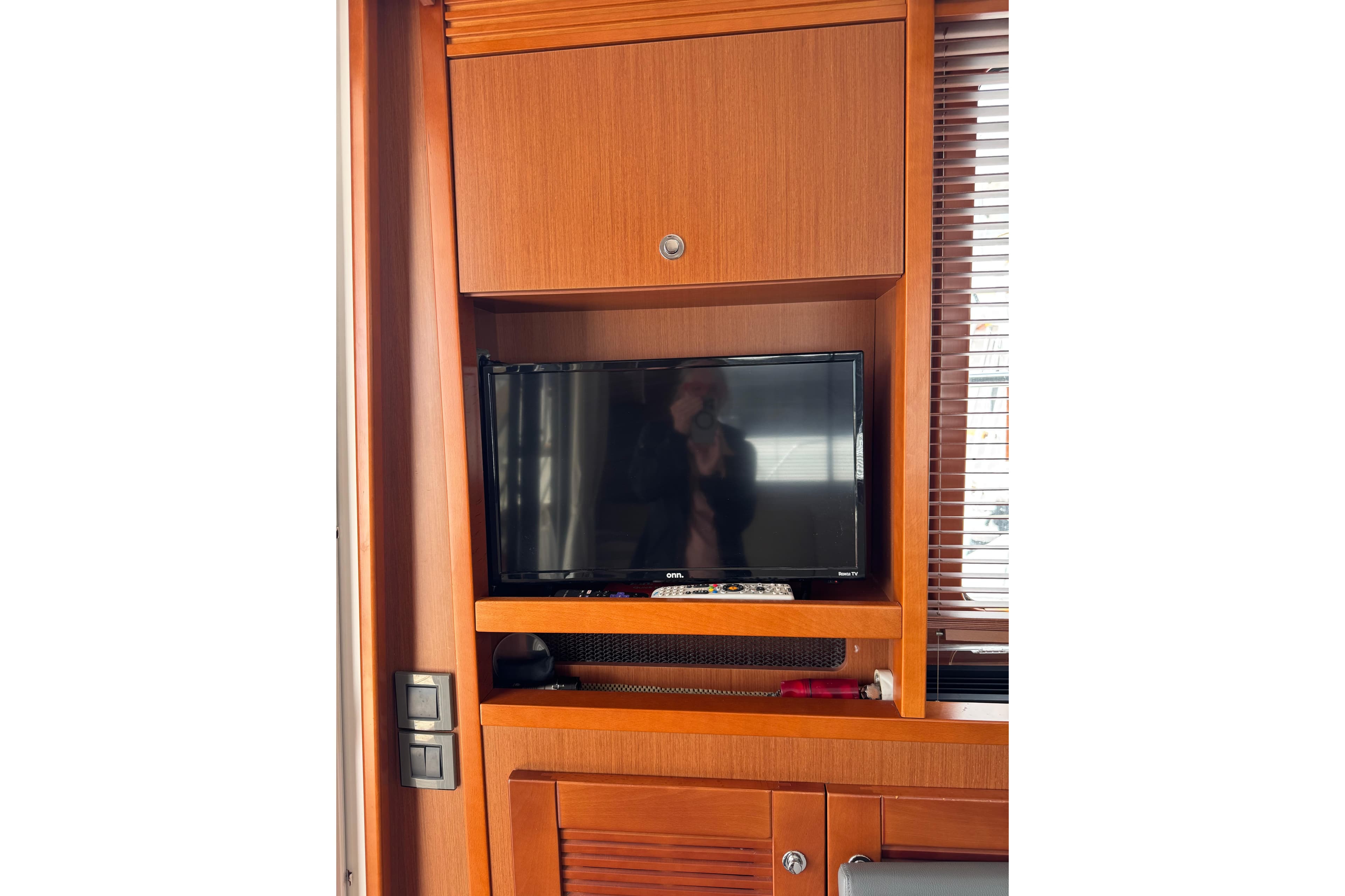 Interior of 2014 Beneteau Swift Trawler 44 with TV and wooden cabinetry.