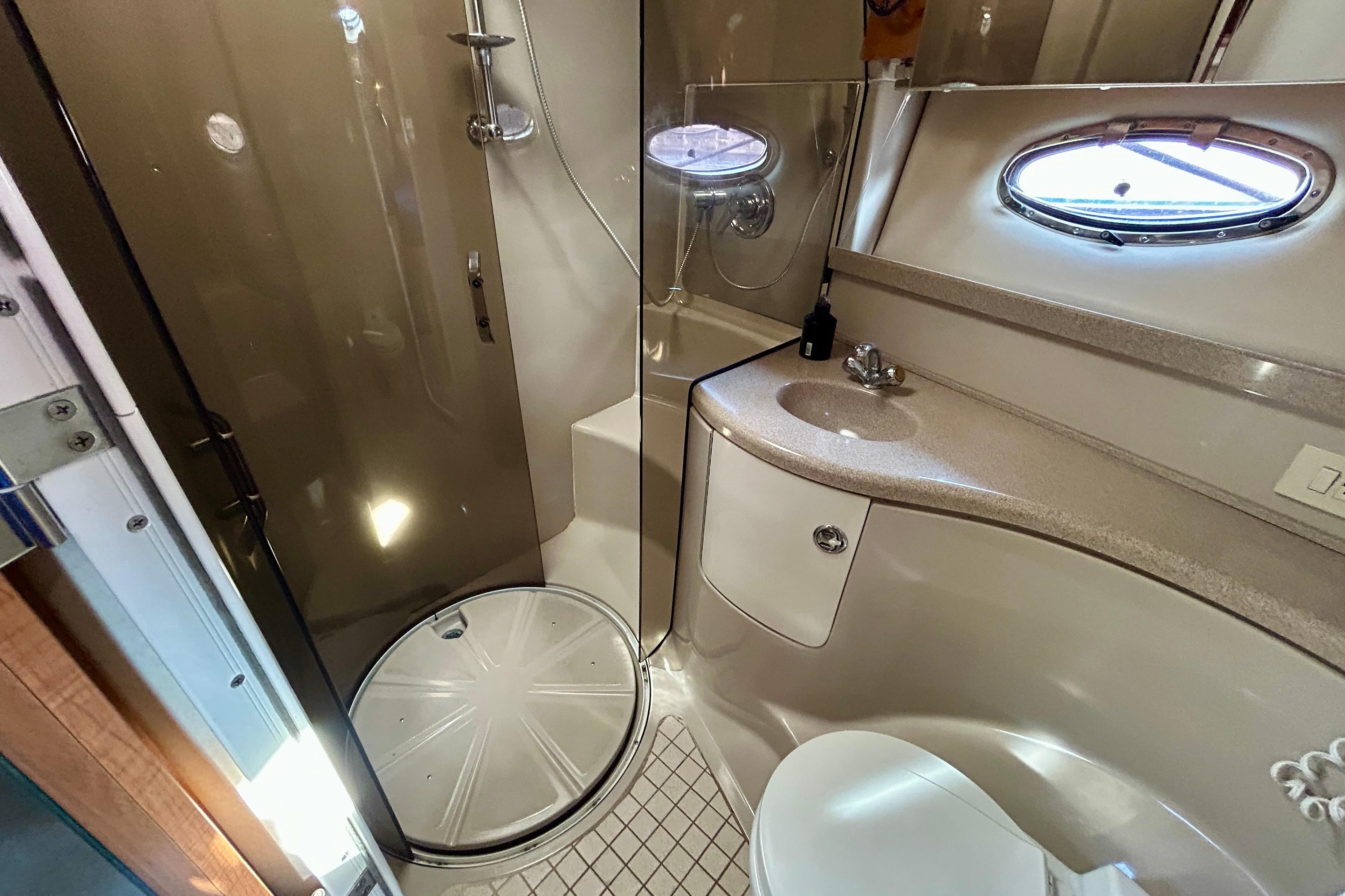 Luxurious bathroom in 2002 Regal Commodore 3860 yacht with shower, sink, and toilet.